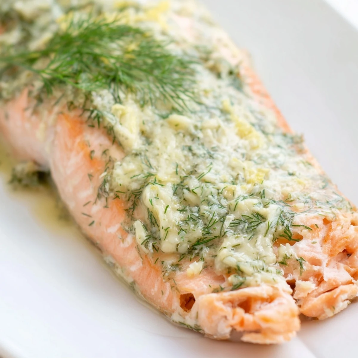Perfectly flaky Baked Salmon with Dill Butter garnished with fresh dill sprigs, ready to serve for dinner.