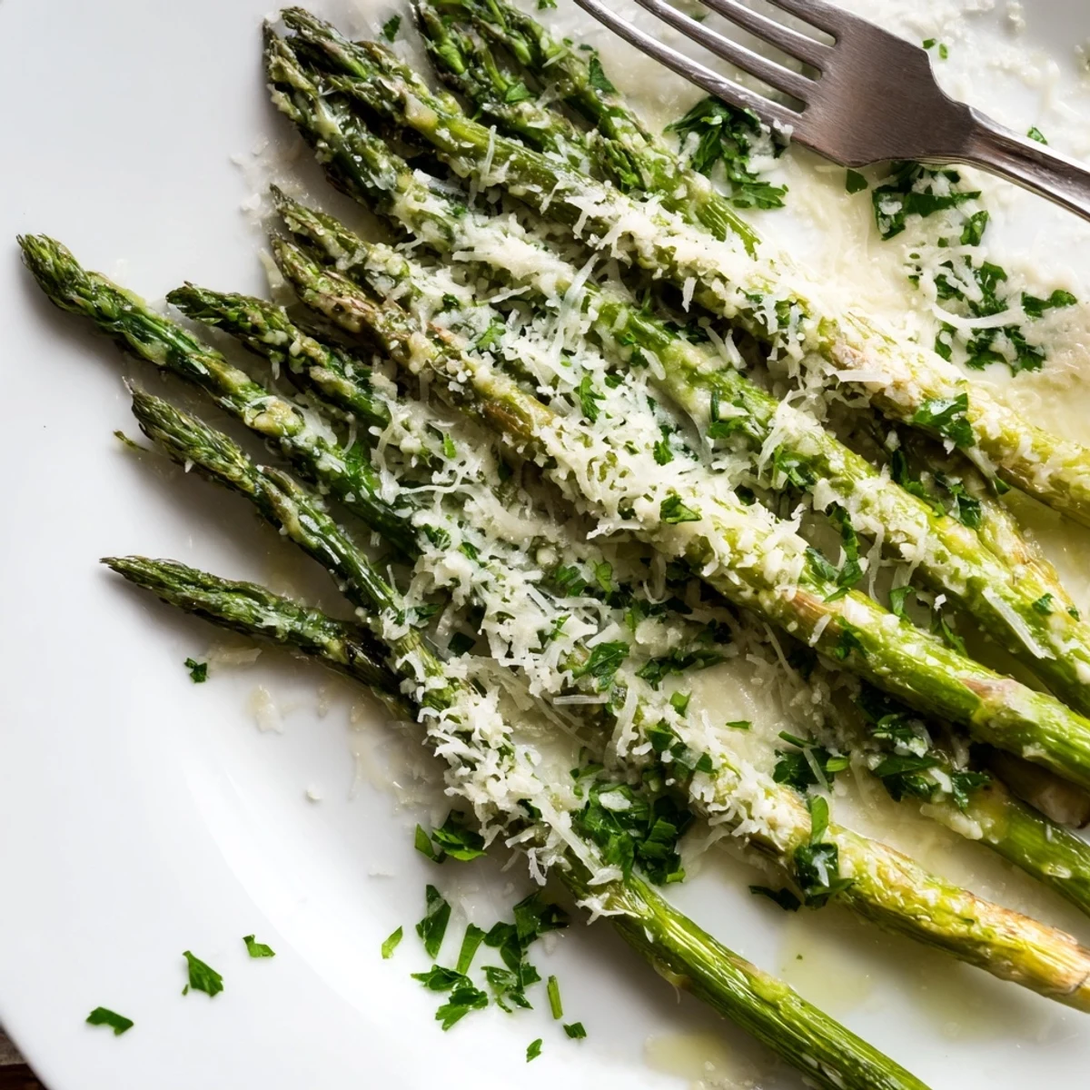 Freshly roasted asparagus spears topped with melted Parmesan and lemon wedges, served hot from the oven.