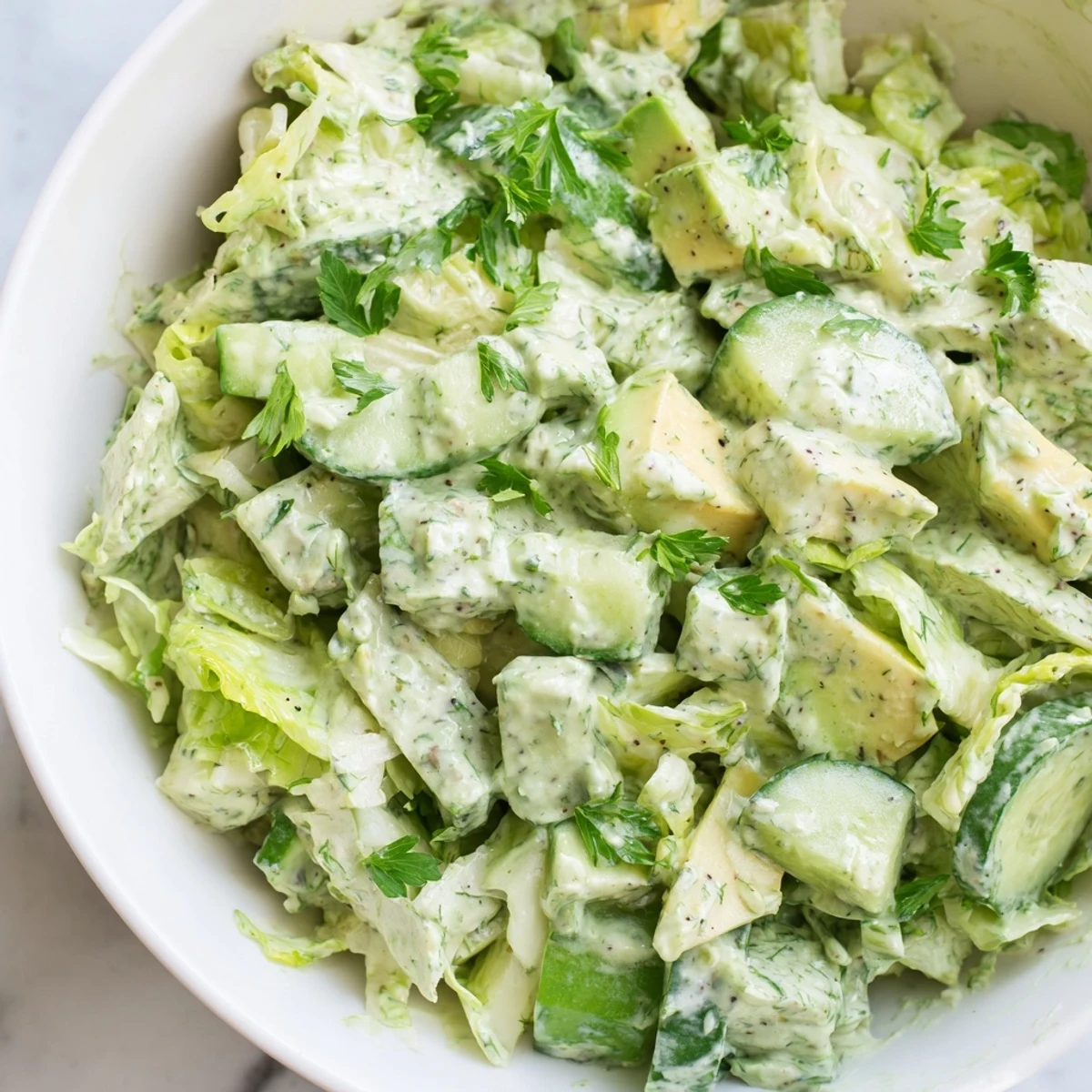 Freshly tossed Green Goddess Salad with crisp romaine, crunchy cabbage, creamy avocado, and drizzled herb-packed dressing.