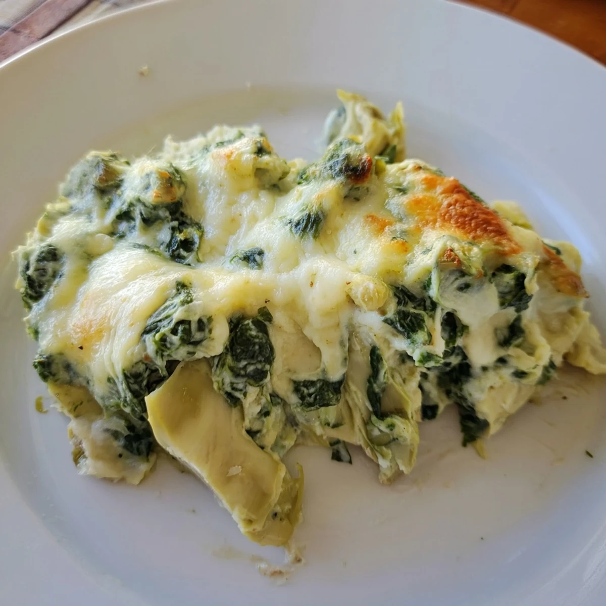 Golden-baked Creamy Spinach and Artichoke Dip in a casserole dish, ready for a party appetizer spread.