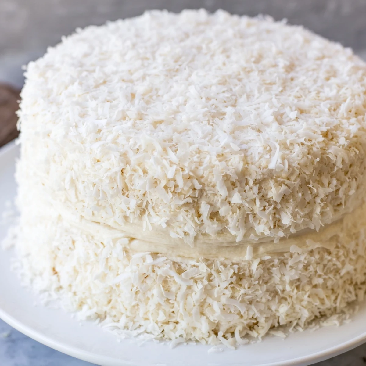 Golden-brown layers of Easter Coconut Cake stacked with fluffy frosting and dusted with coconut for a festive touch.