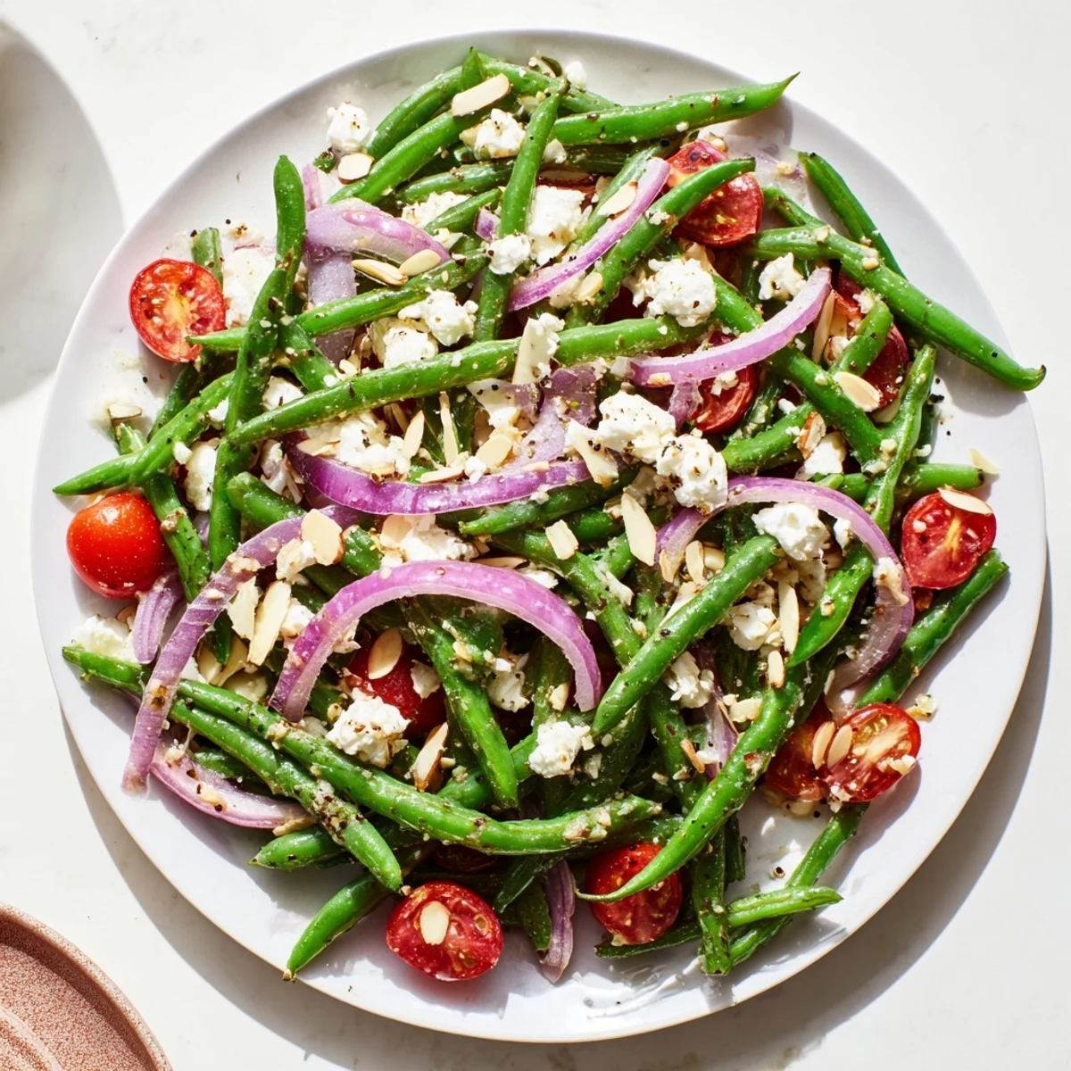 This vibrant Mediterranean salad showcases crisp beans and crumbled cheese, dressed with lemon and olive oil for a refreshing side dish.