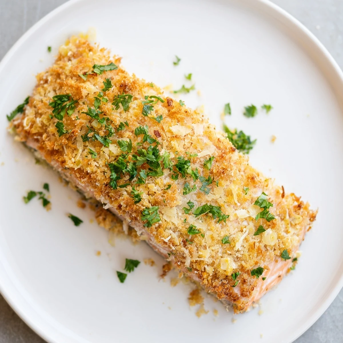 A finished Crispy Parmesan Salmon Bake served with roasted asparagus and a glass of chilled white wine on the side.