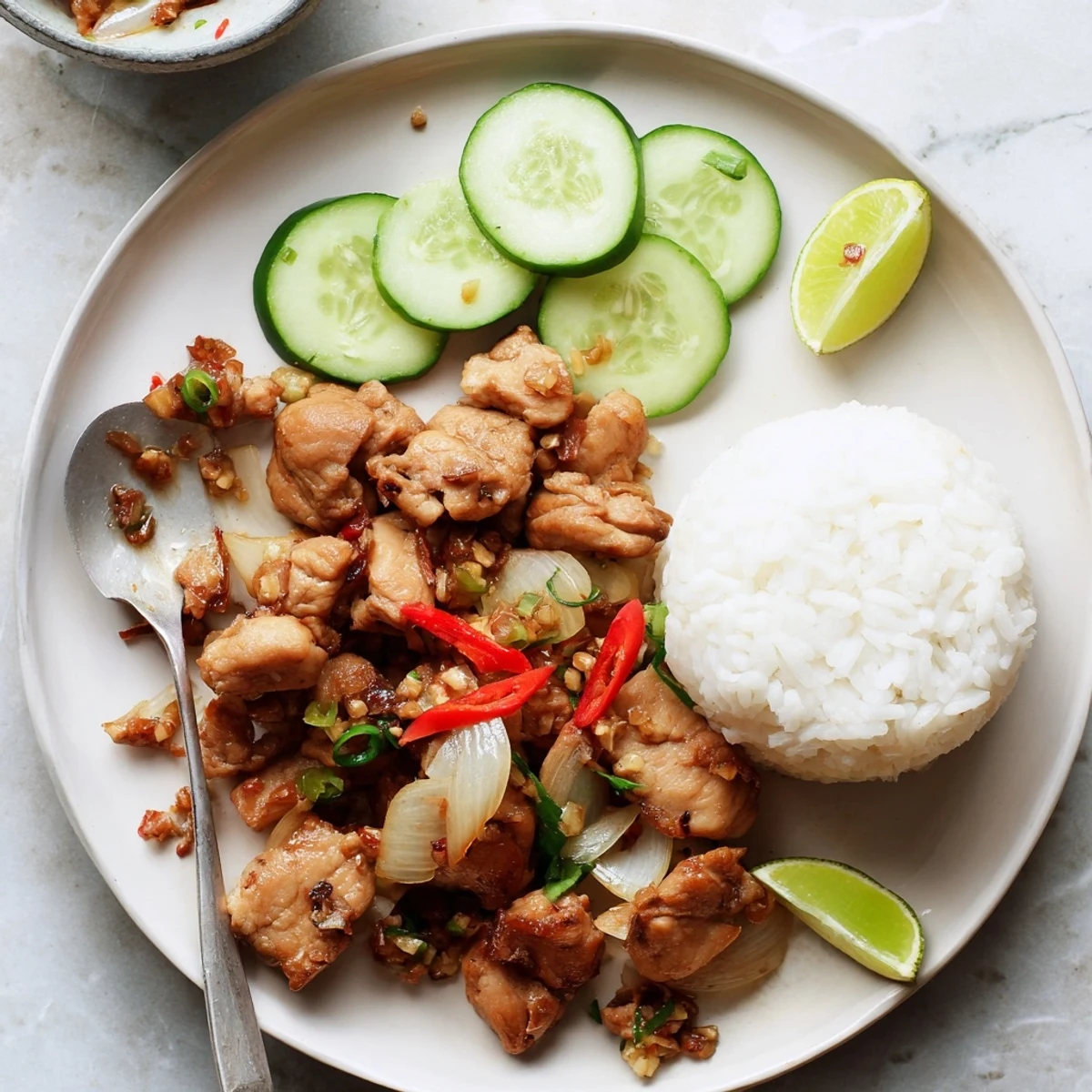 Golden-brown Vietnamese Lemongrass Chicken glistening with aromatic stir-fry sauce in a hot wok with onions.