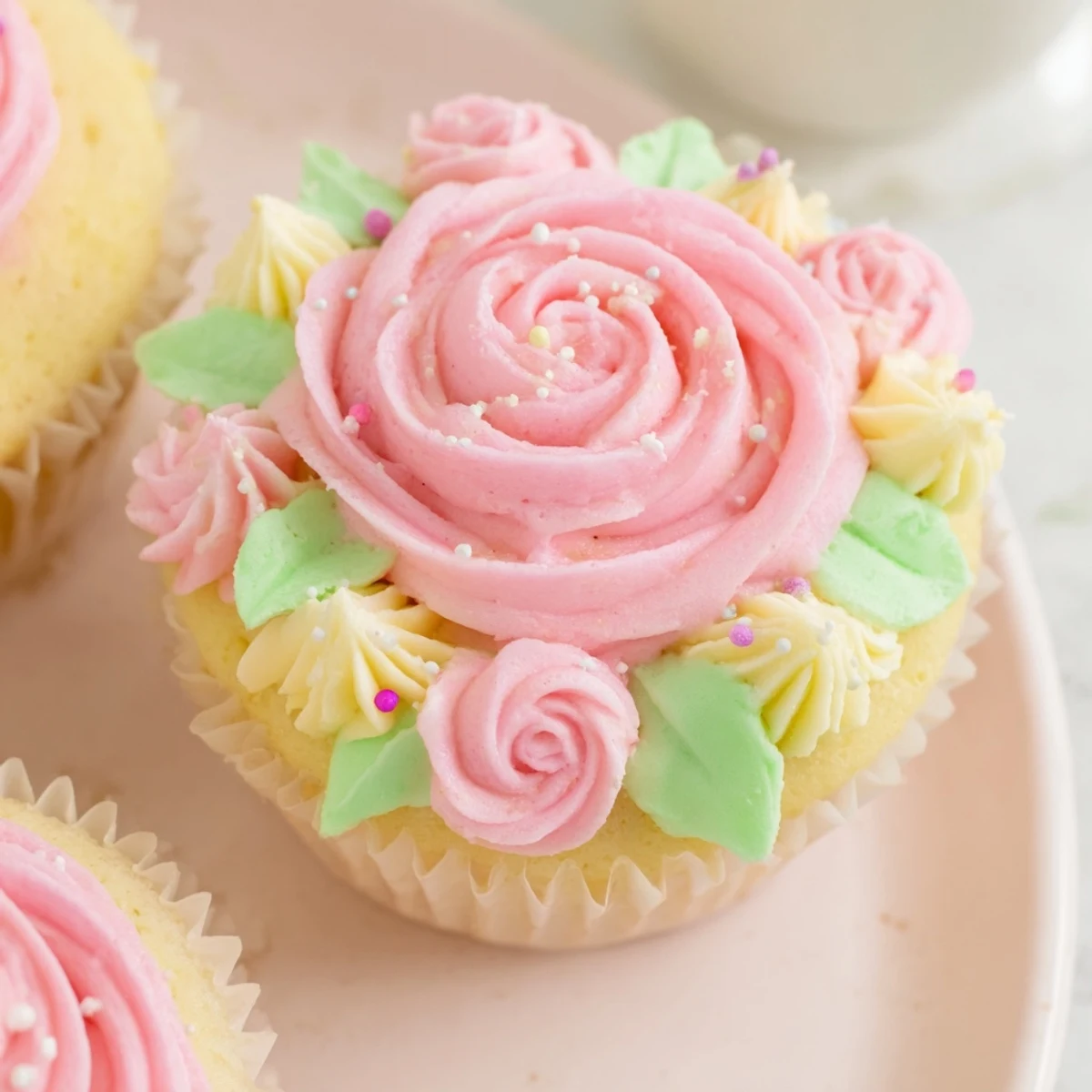 Soft vanilla cupcakes topped with pink and yellow floral buttercream, perfect for baby showers.