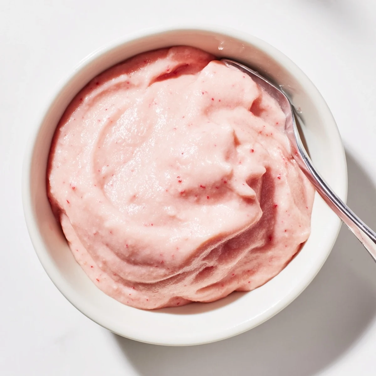 Silky smooth pink lemon curd spread on freshly baked scones for afternoon tea