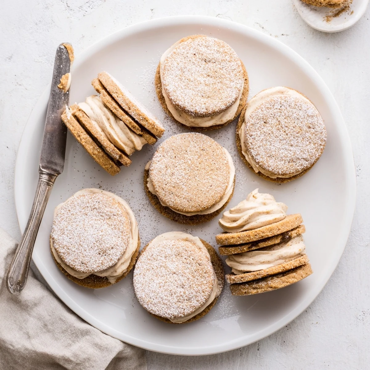 Golden chai shortbread cookie sandwiches with creamy spiced filling between two buttery cookies