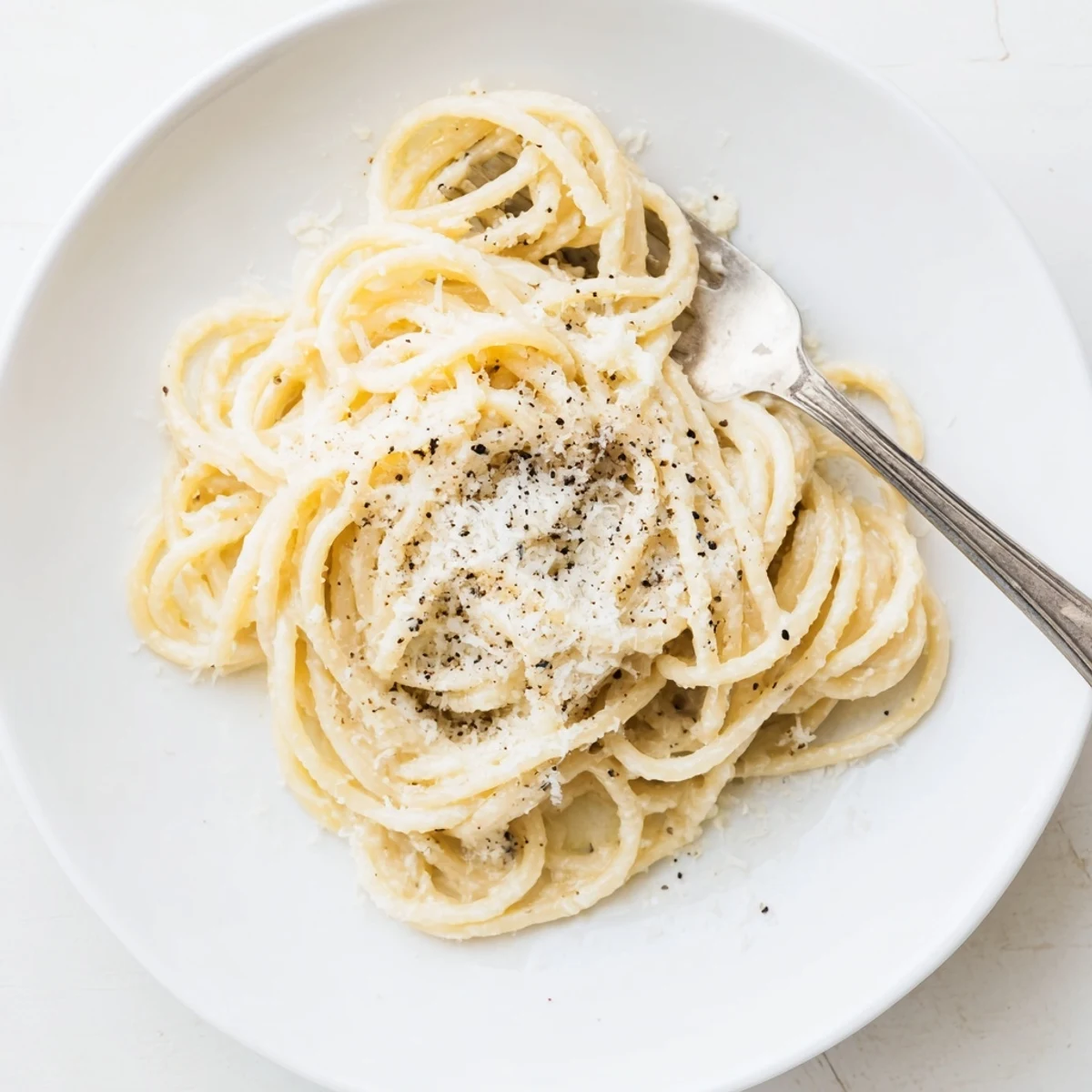 Creamy Cacio e Pepe pasta coated in glossy Pecorino Romano sauce with freshly ground black pepper