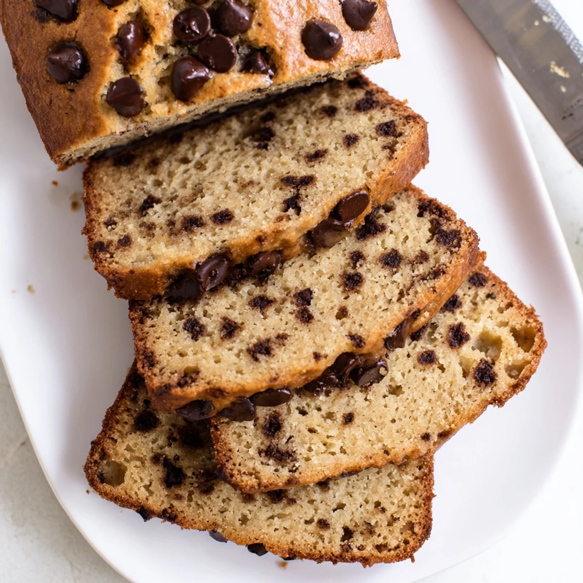 Golden loaf of classic chocolate chip banana bread with melty chips on top