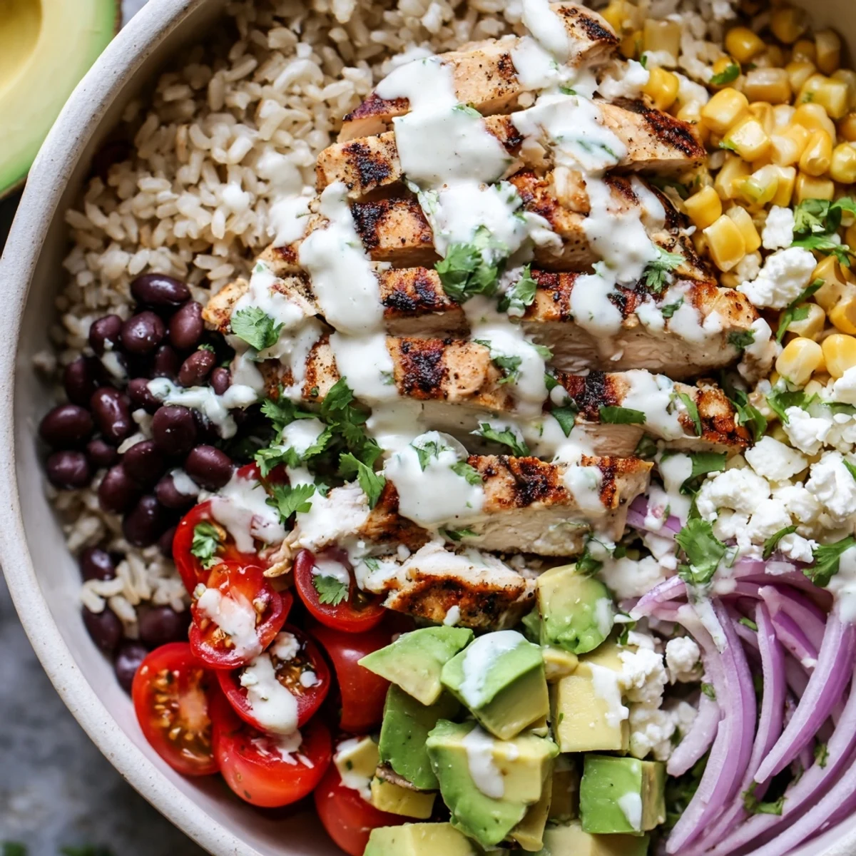 Colorful protein packed street corn chicken bowl with grilled chicken, charred corn, avocado, and creamy lime drizzle