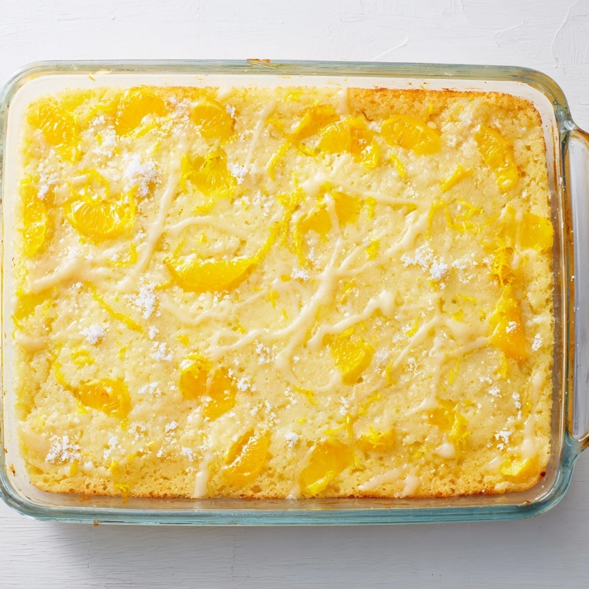 Warm lemon dump cake topped with mandarin oranges and sprinkled with lemon zest