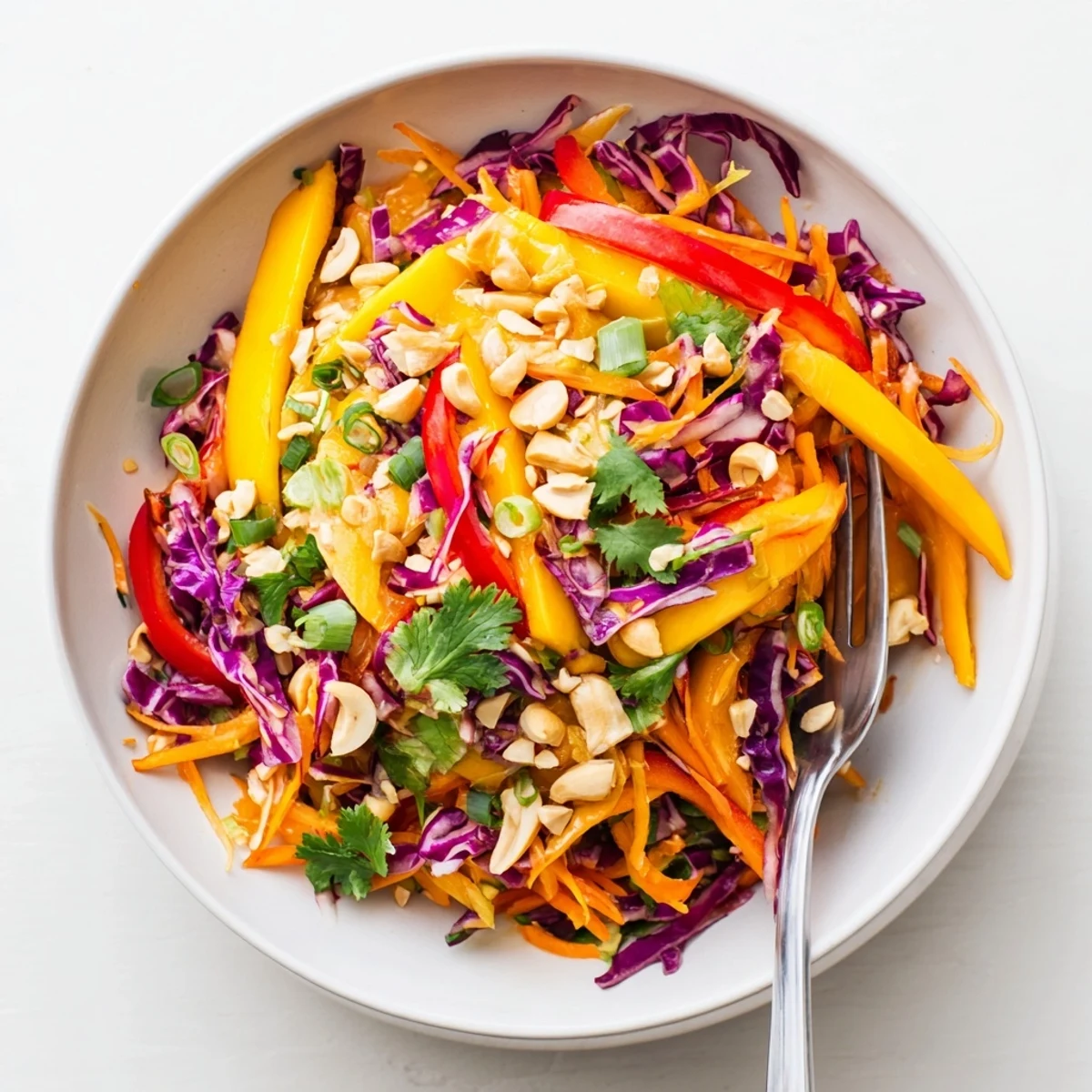 Vibrant mango slaw bowl with red bell pepper and green onions dressed in lime vinaigrette