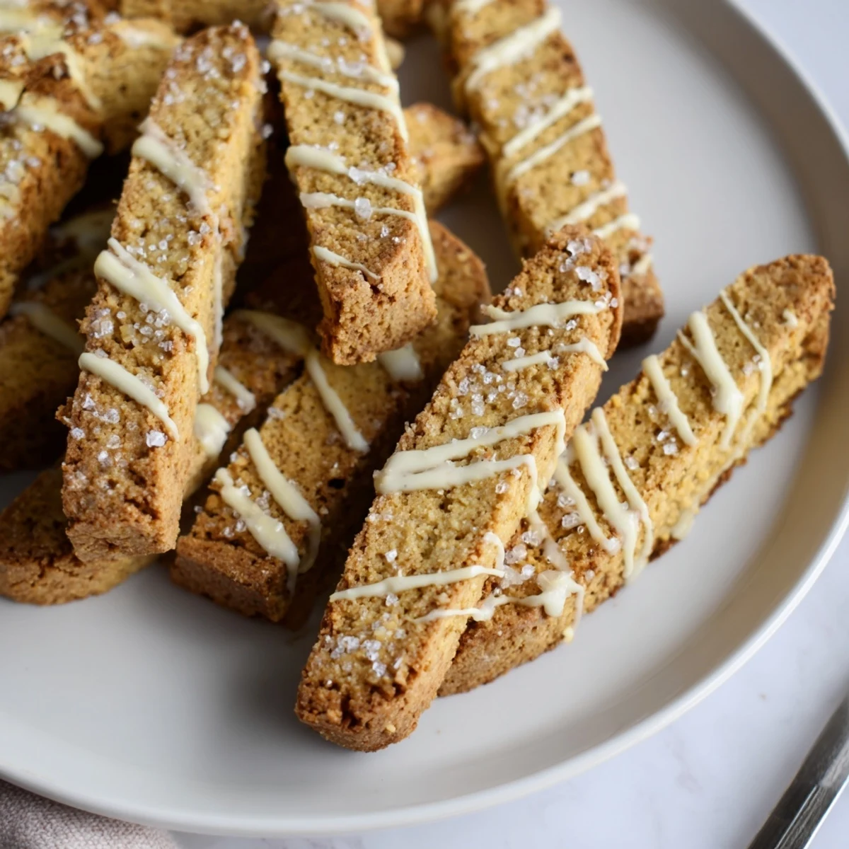 Buttery sugar cookie biscotti halves stacked neatly with sparkling sugar topping visible