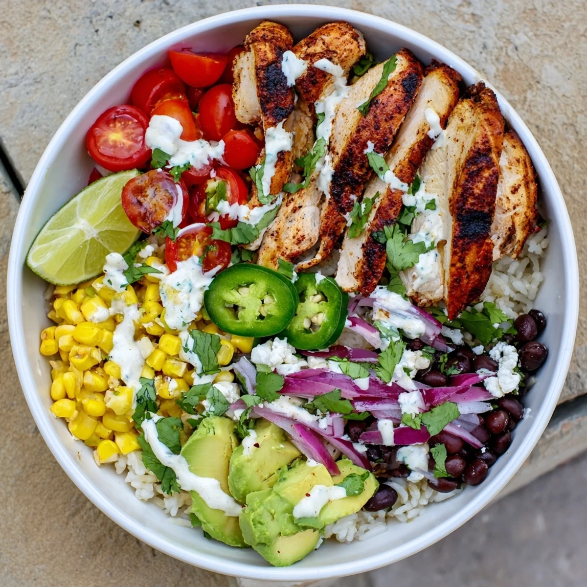 Golden grilled chicken atop cilantro lime rice in this Ultimate Baja Style Chicken Bowl with black beans and corn.