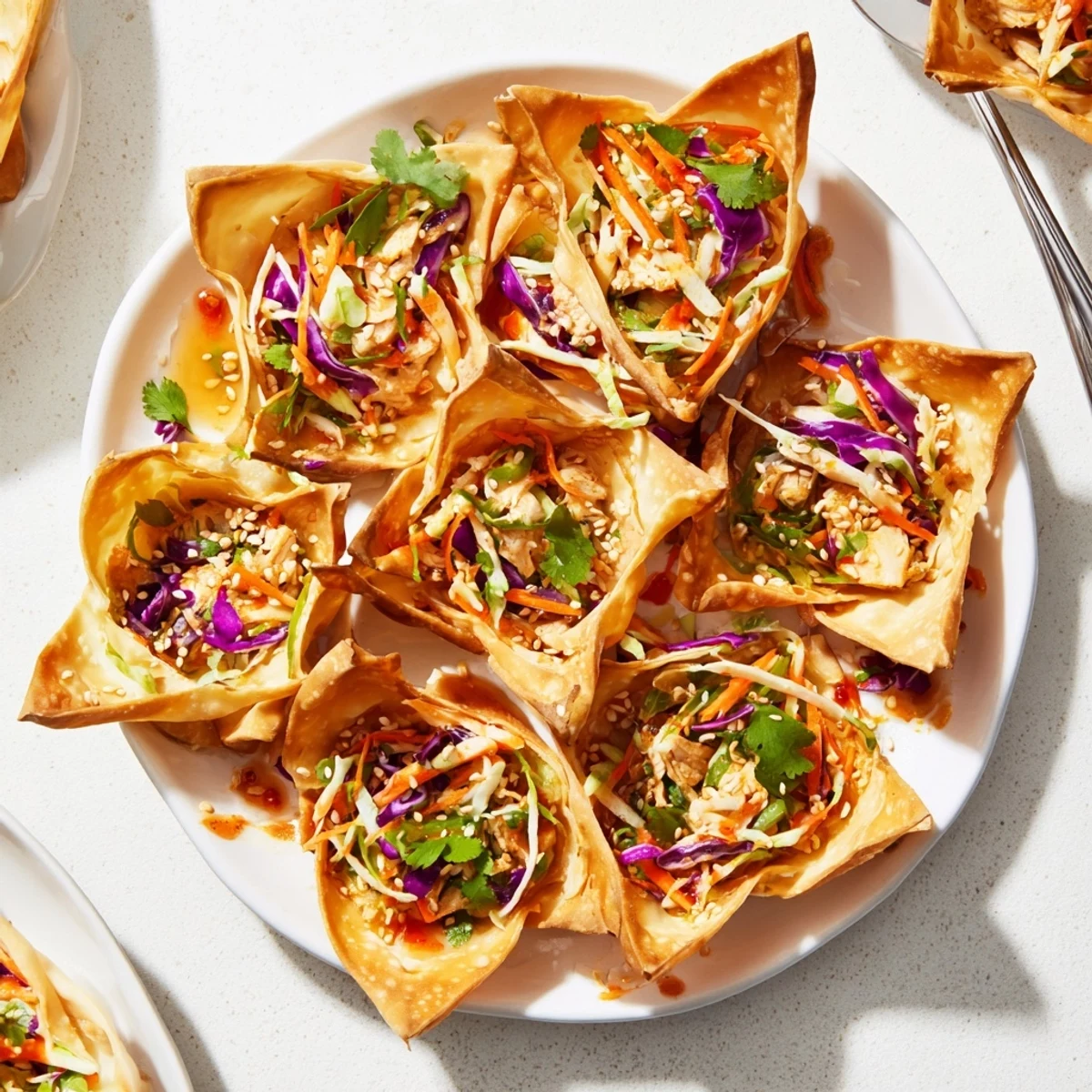 Golden crispy chicken wonton tacos topped with colorful Asian slaw and sweet chili sauce drizzle