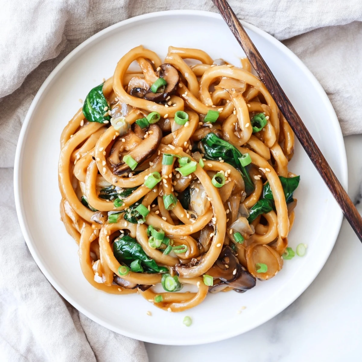 Creamy miso udon noodles coated in savory white miso sauce with tender shiitake mushrooms and wilted spinach