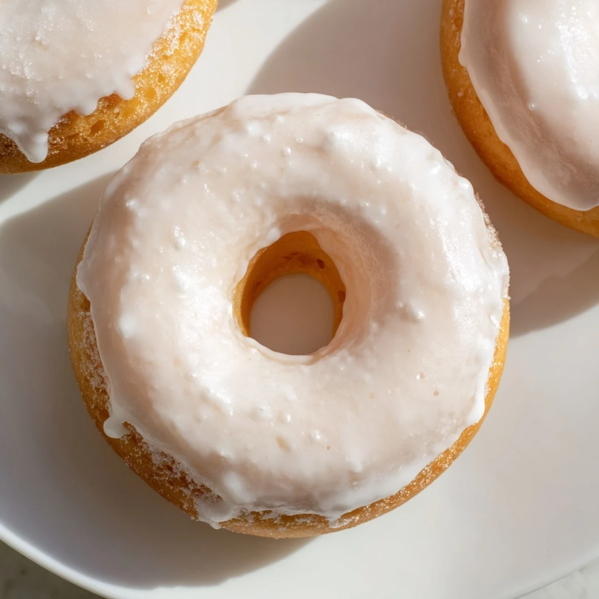 Golden baked Greek yogurt cake donuts with vanilla glaze dripping down the sides