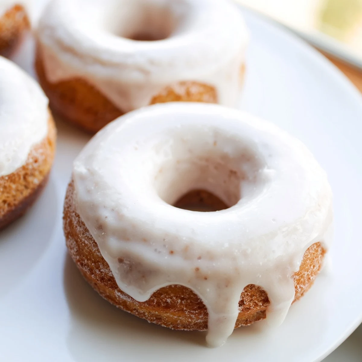 Batch of twelve Greek yogurt cake donuts arranged on a white serving platter