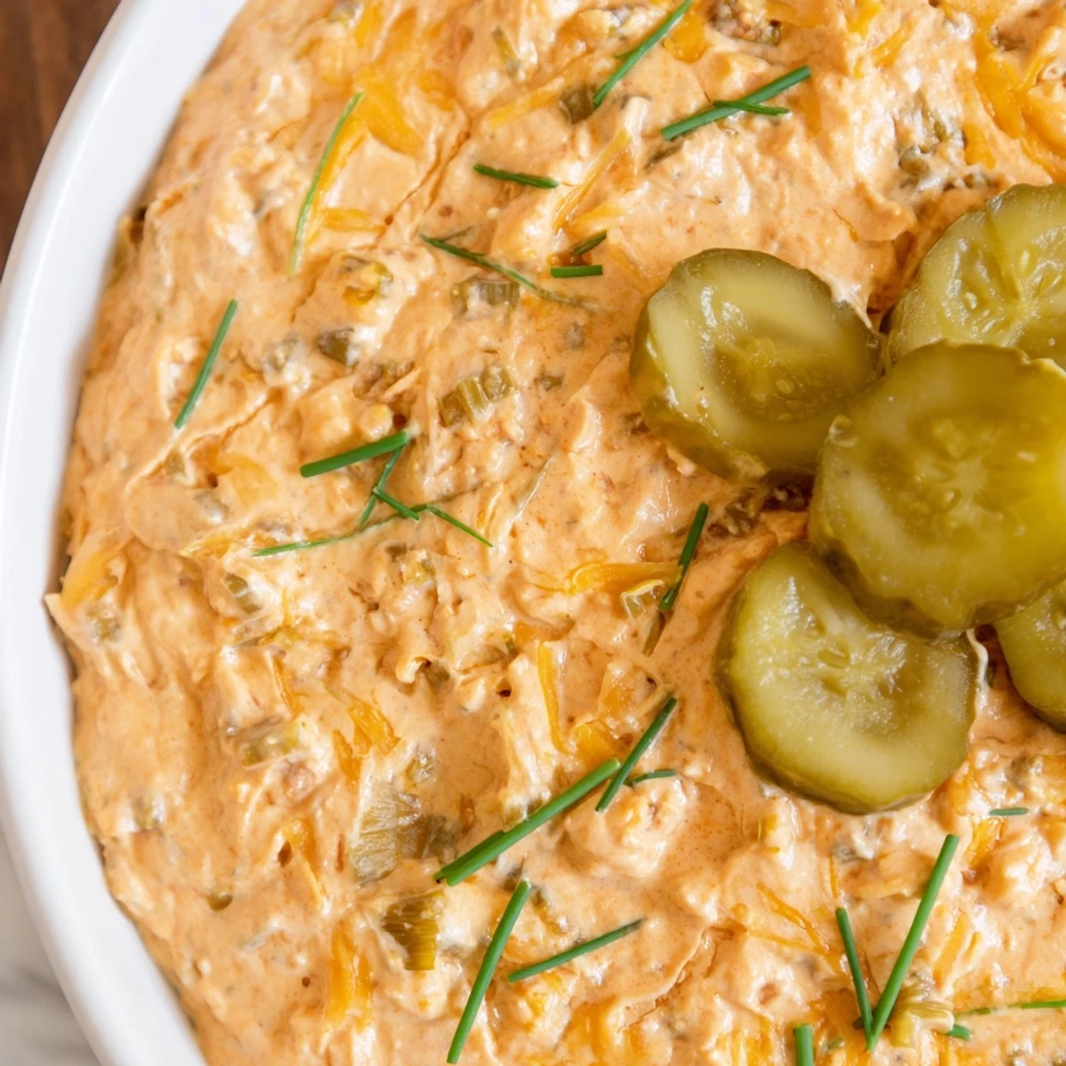 Creamy buffalo pickle dip served in a bowl with crispy chips for game day snacking
