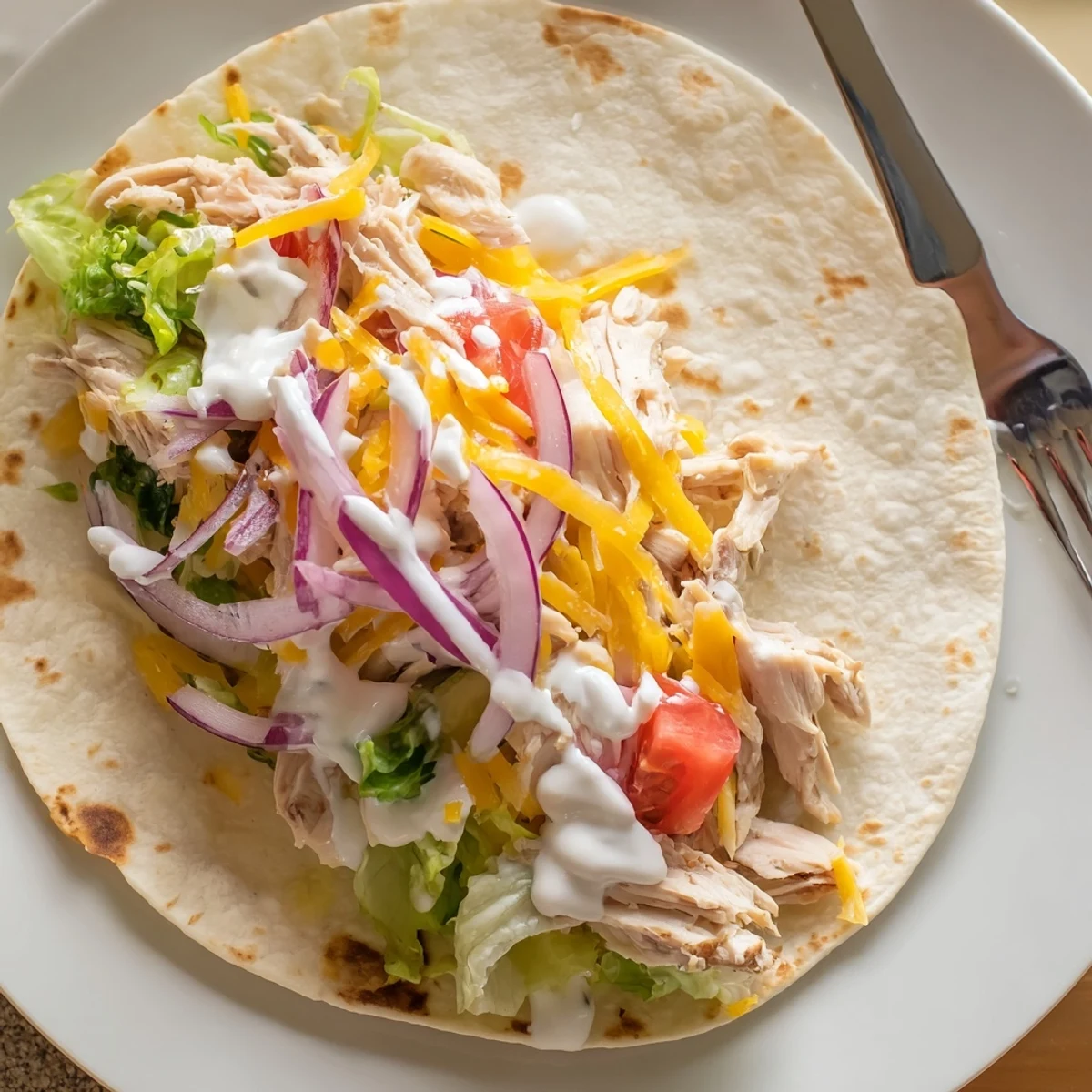 Cheesy Garlic Chicken Wraps with melted cheddar, warm tortilla, crisp romaine.