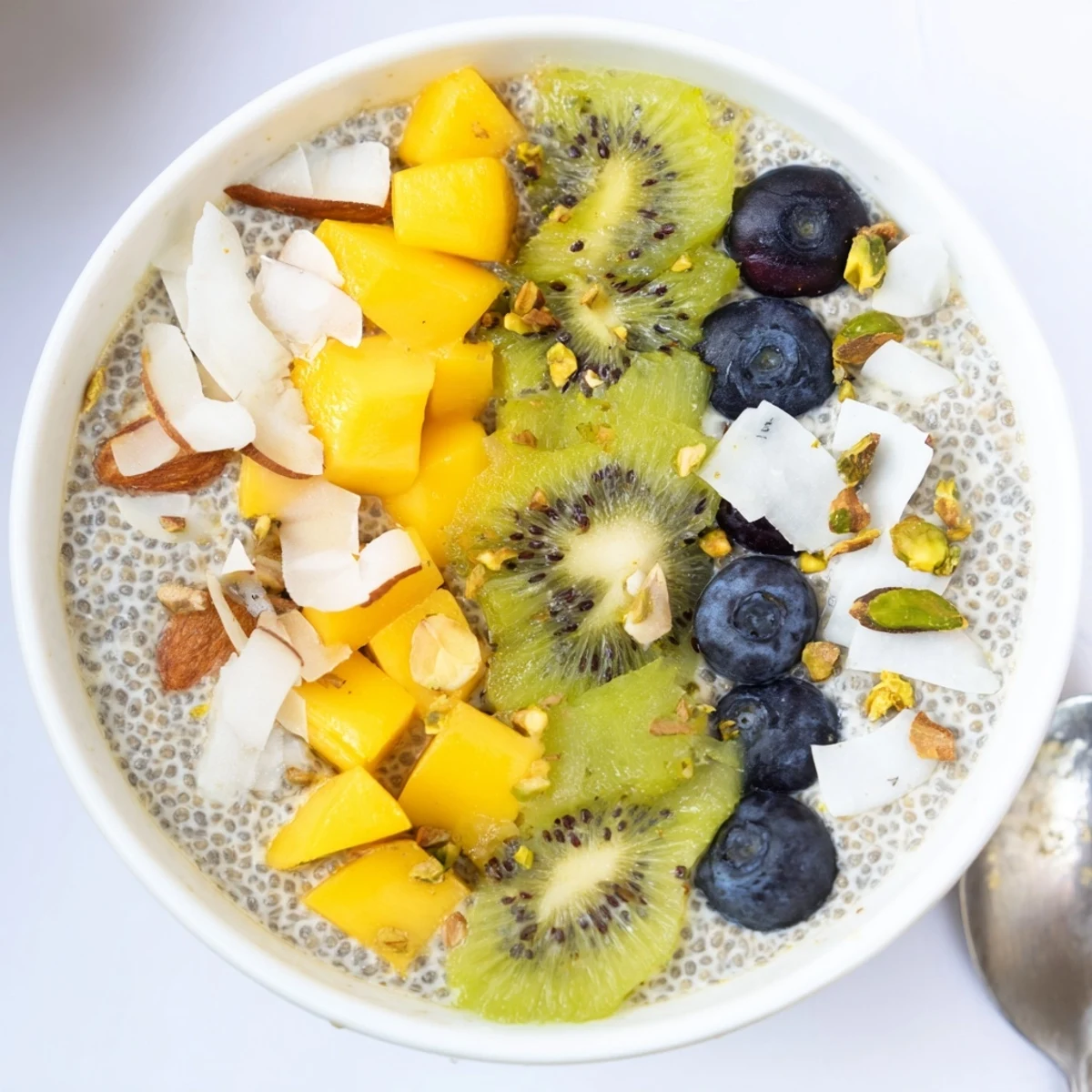 Creamy Coconut Chia Pudding topped with mango and toasted coconut flakes