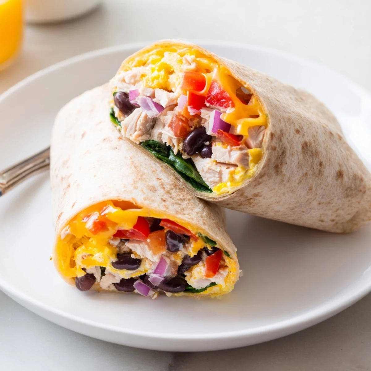 Cut Protein Breakfast Burrito revealing fluffy scrambled eggs, spinach, black beans.