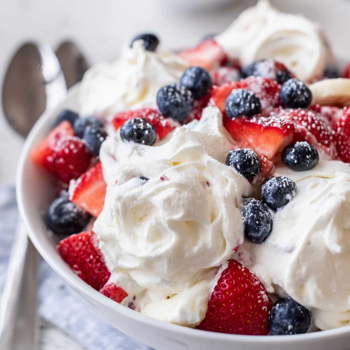 Chilled Red White And Blue Cheesecake Salad layered with bananas, tart lemon, vibrant berries