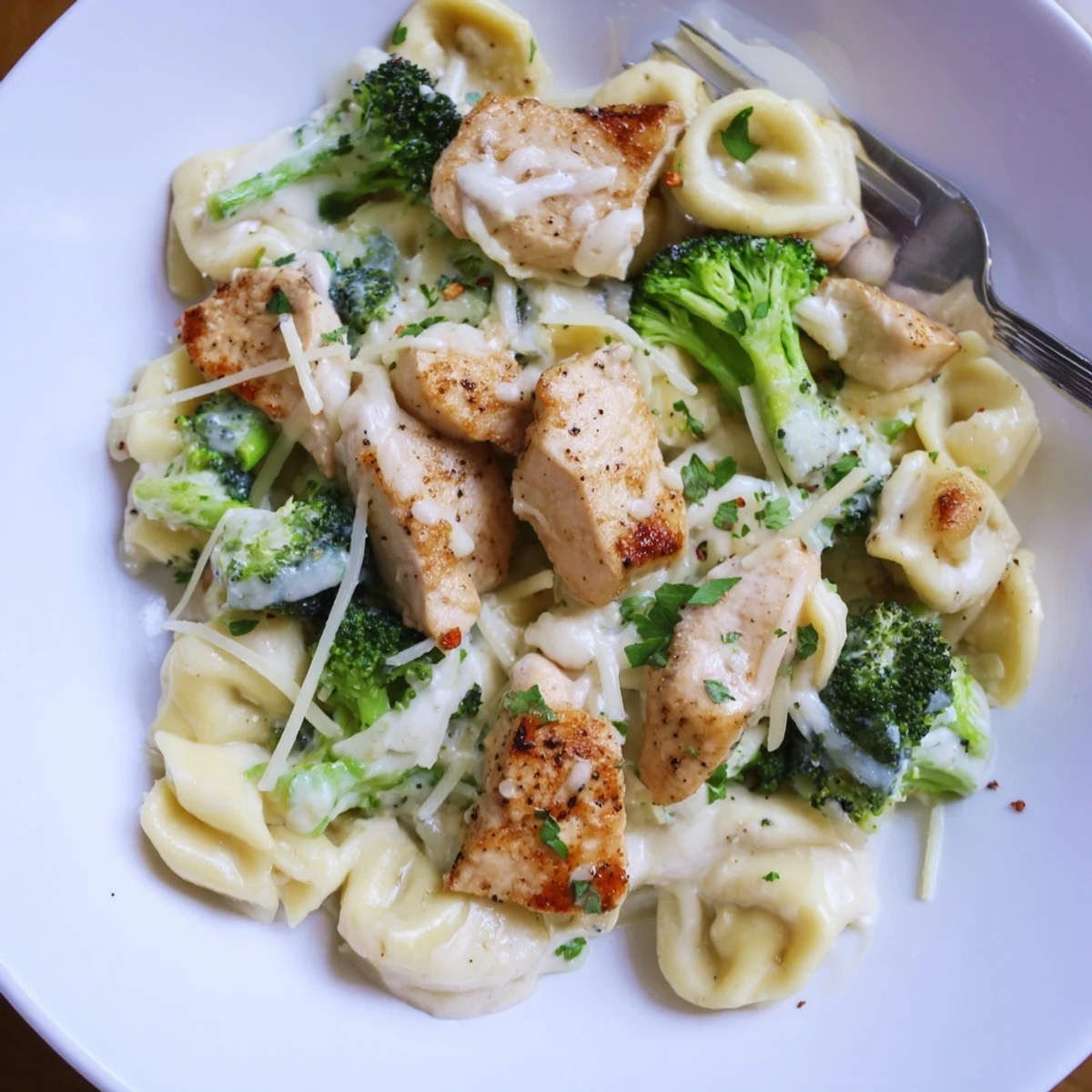 Bowl of Creamy Garlic Parmesan Tortellini Chicken Broccoli, tender pasta and cheesy aroma