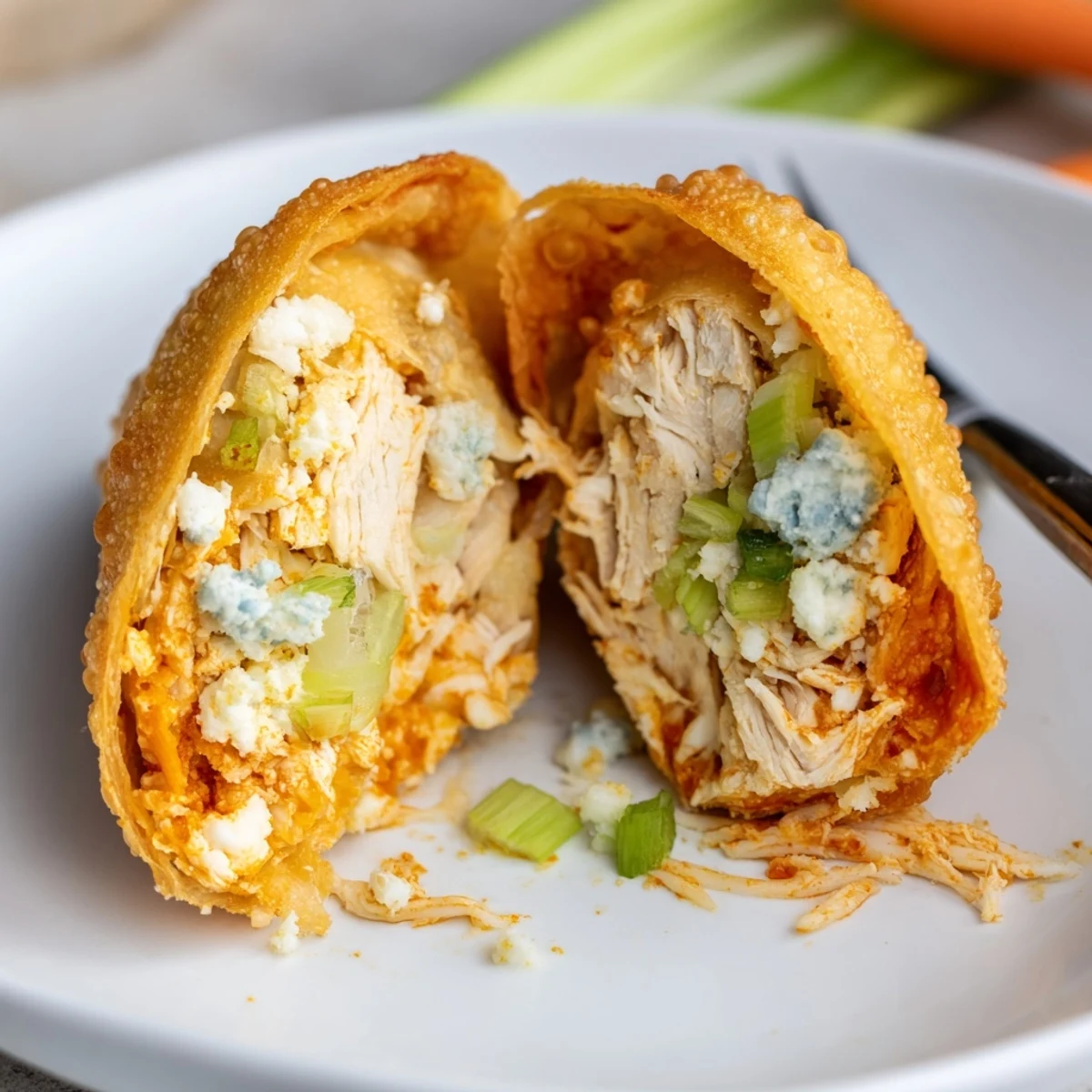 Handheld Buffalo Chicken Egg Rolls served with blue cheese dip and celery
