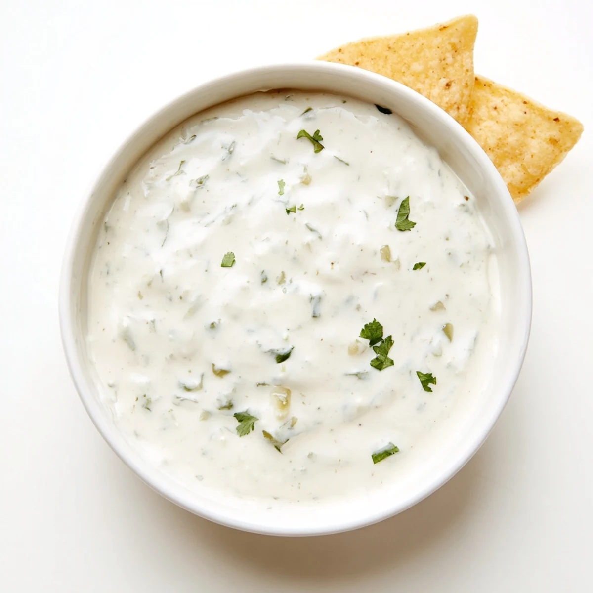 Creamy white Mexican sauce drizzled over crispy tacos and fresh cilantro garnish