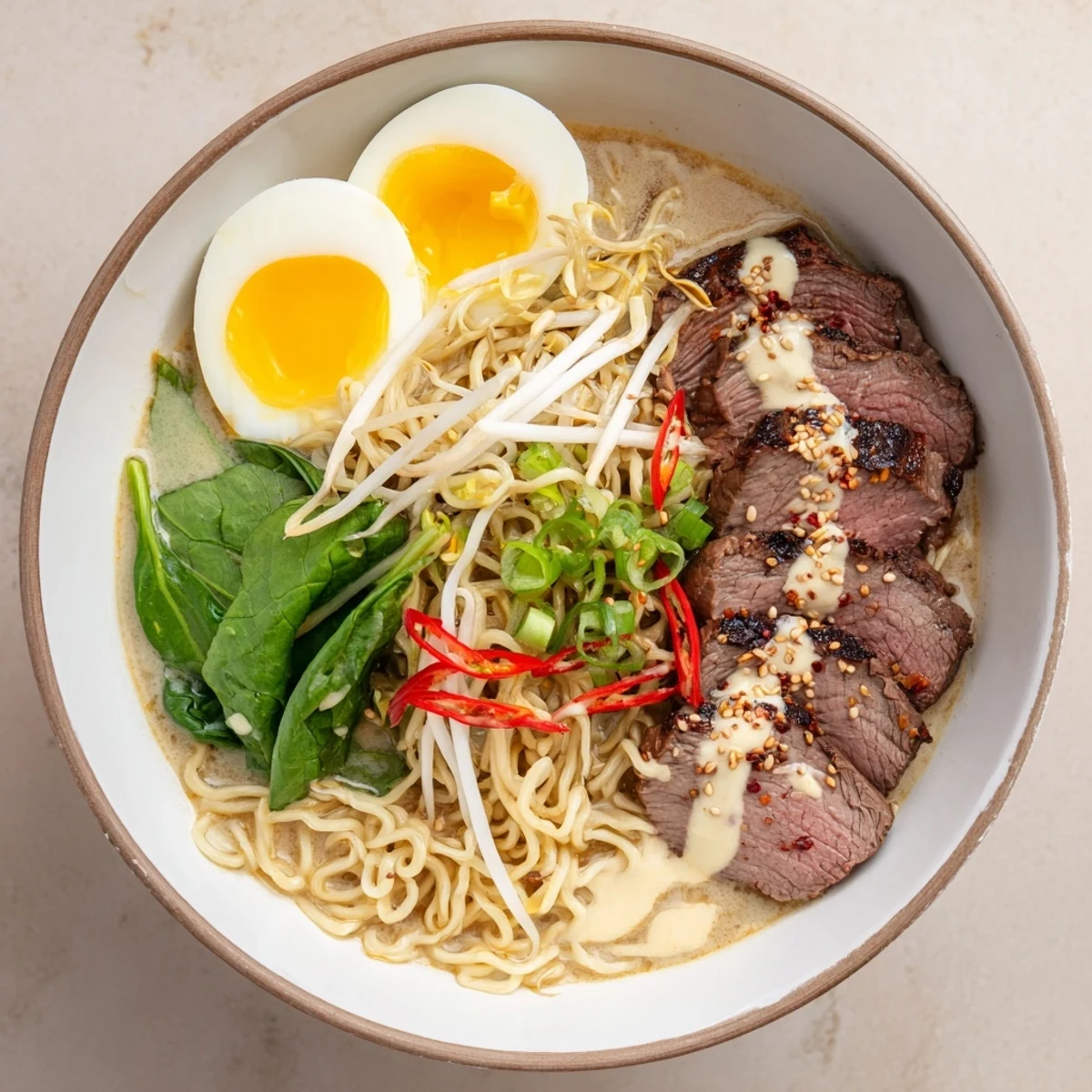 Rich Japanese fusion ramen featuring tender spicy beef slices in aromatic broth topped with soft-boiled eggs