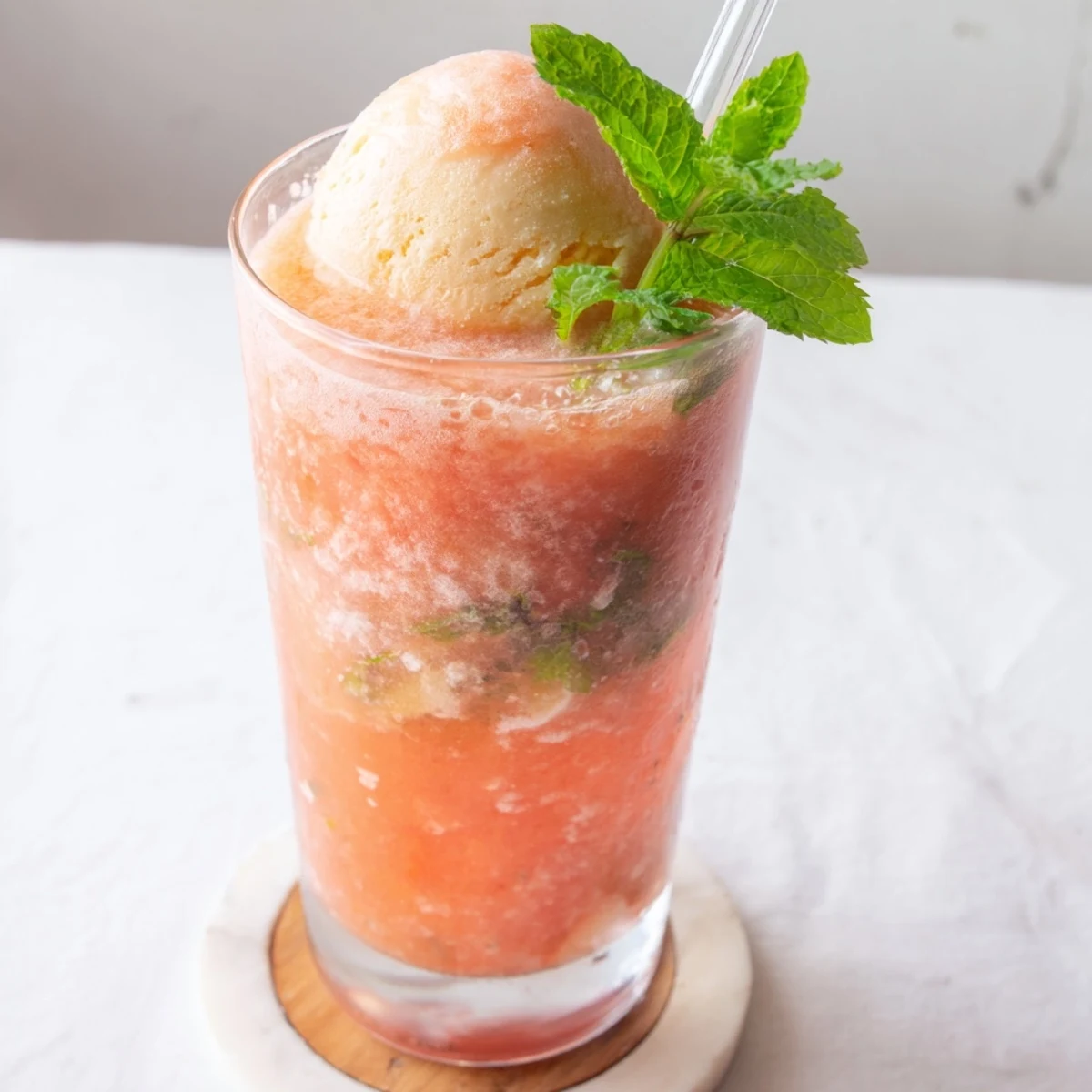 Refreshing watermelon mango float drink showcasing swirling fruit puree beneath creamy vanilla ice cream