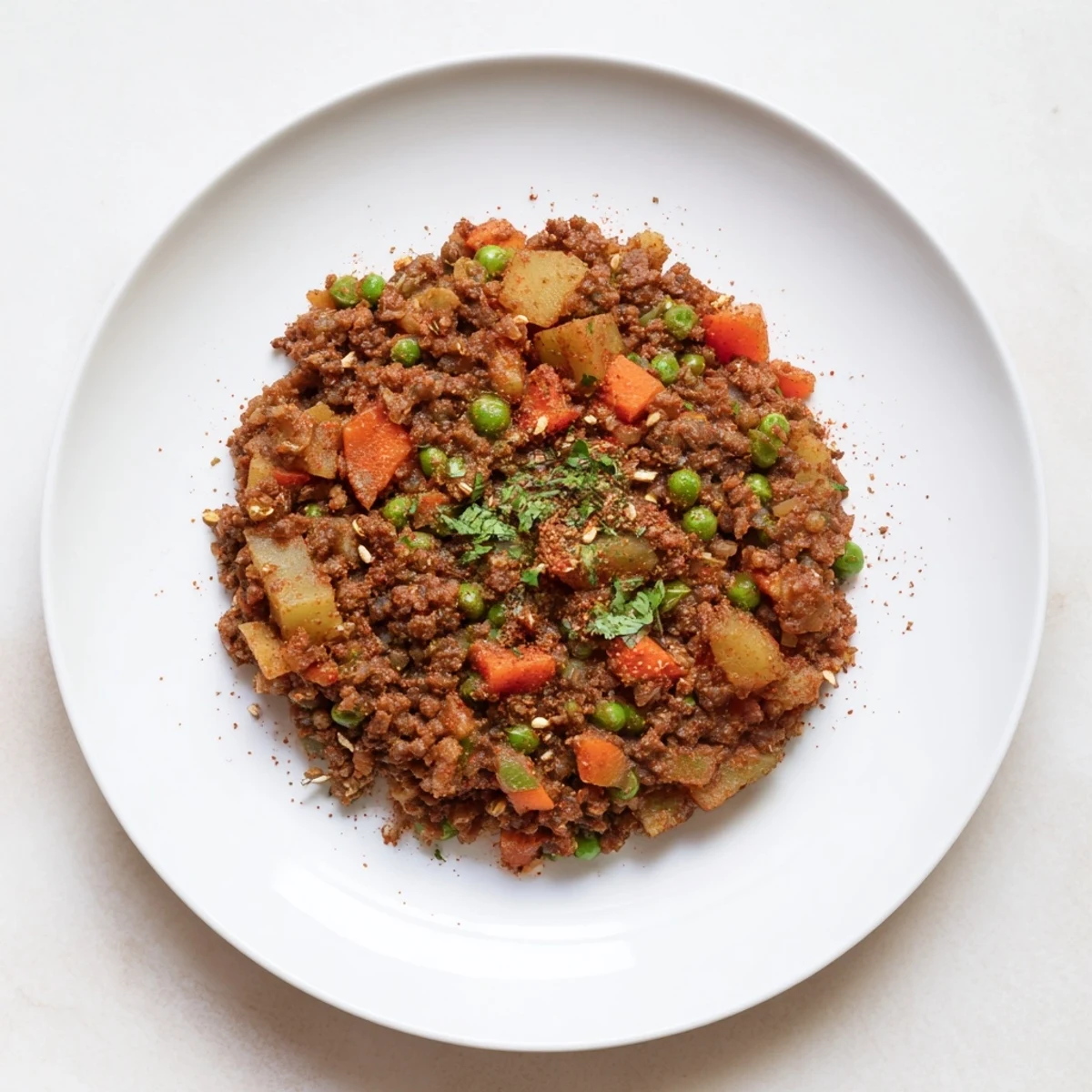 Hearty Potato Mince spooned over steamed rice, tender meat and peas