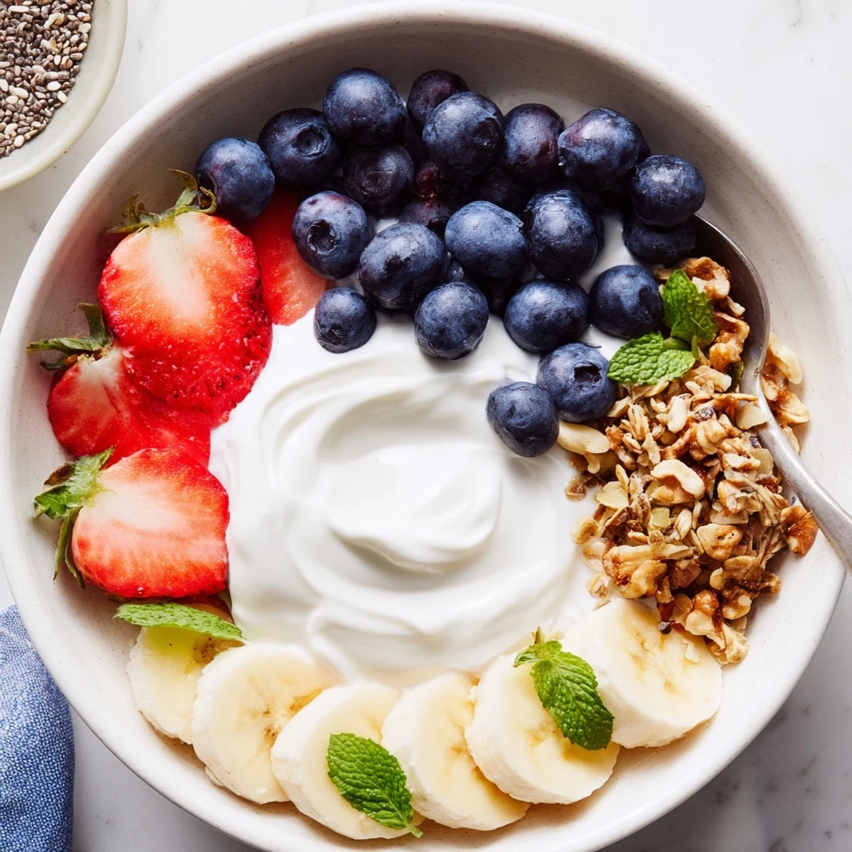 Bright Blueberry Breakfast Salad Recipe topped with granola and toasted walnuts