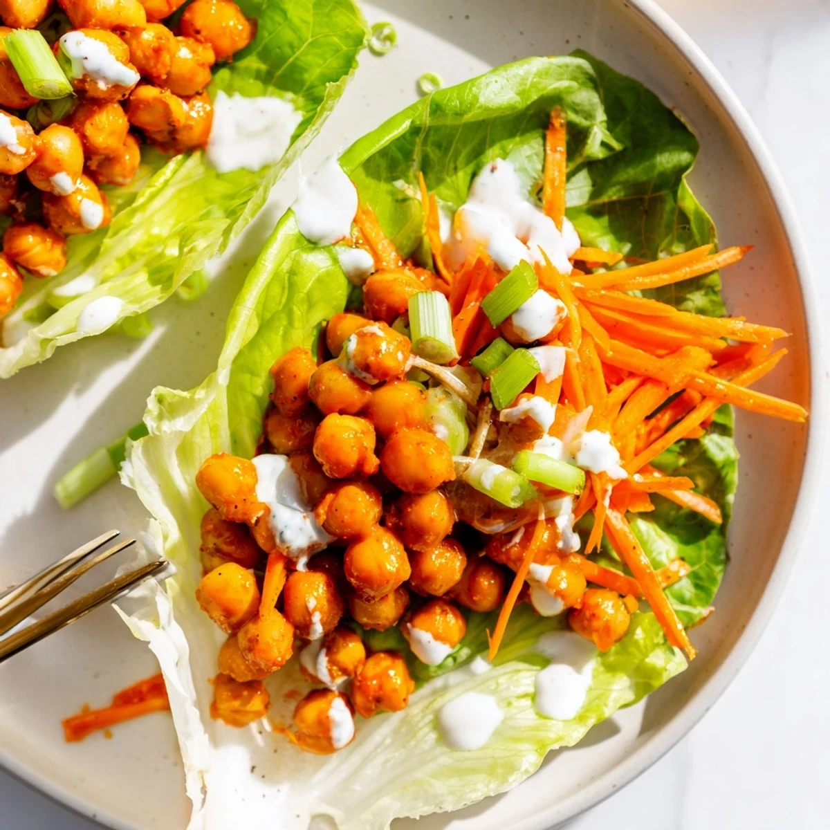 Buffalo Chickpea Lettuce Wraps piled on platter, spicy chickpeas, crisp lettuce  