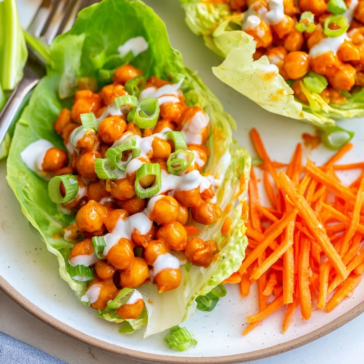 Overhead shot of Buffalo Chickpea Lettuce Wraps with creamy vegan ranch drizzle  