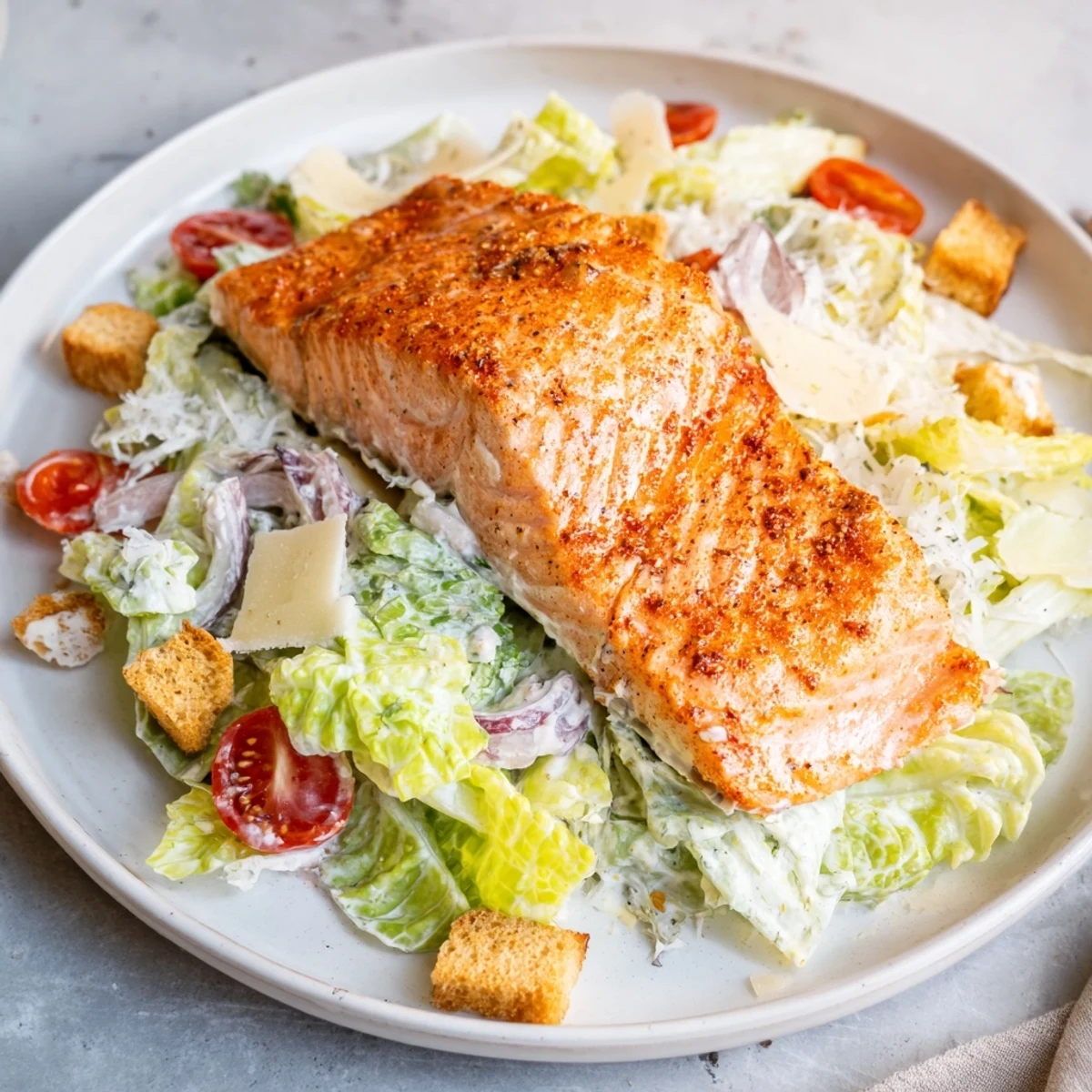Smoky Salmon Caesar Salad heaped with flaky salmon, crisp romaine, shaved Parmesan