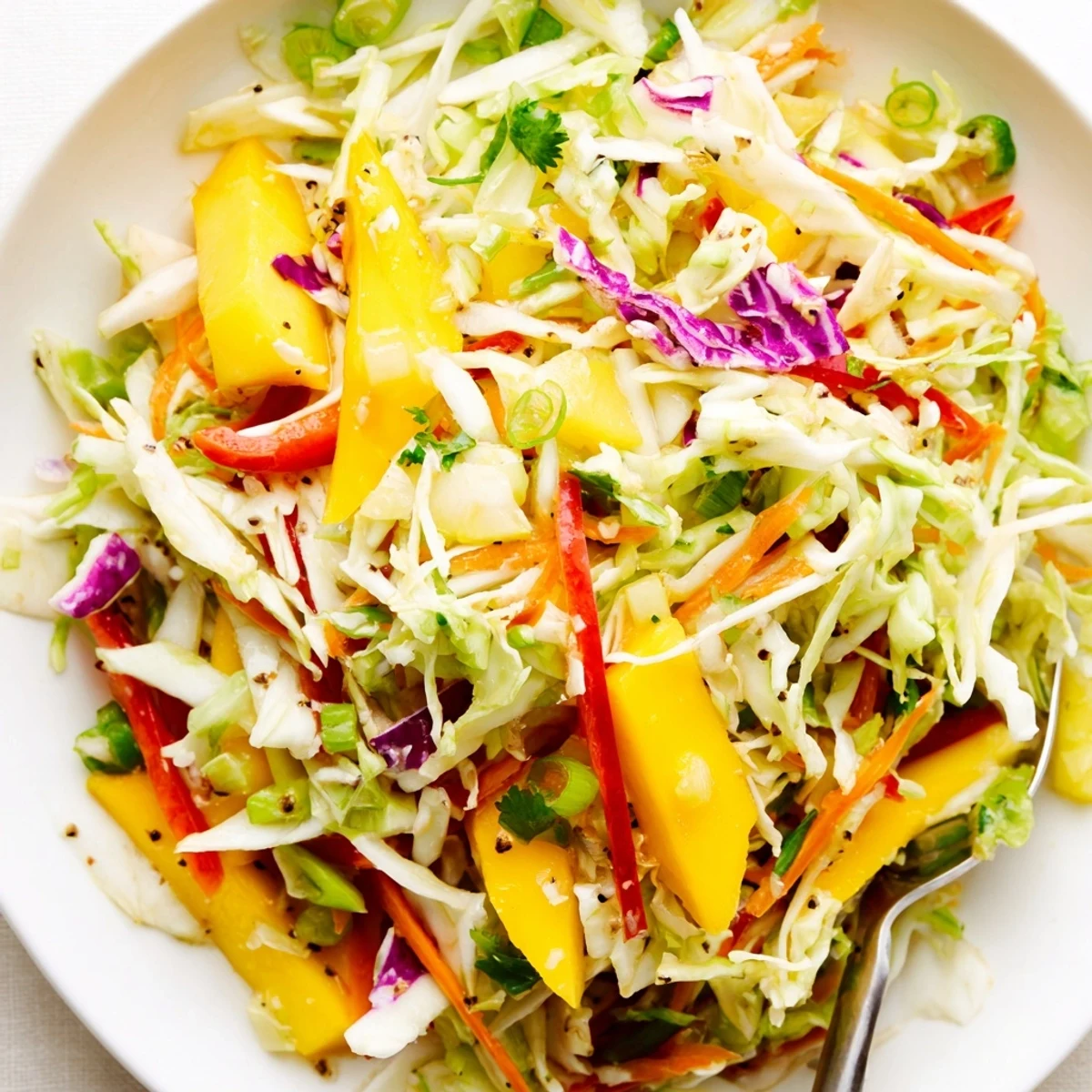 Mango Cabbage Citrus Slaw piled in bowl, tangy citrus aroma, crisp texture