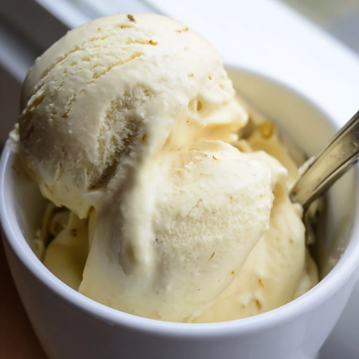 Creamy golden scoops of dandelion honey ice cream garnished with fresh yellow petals