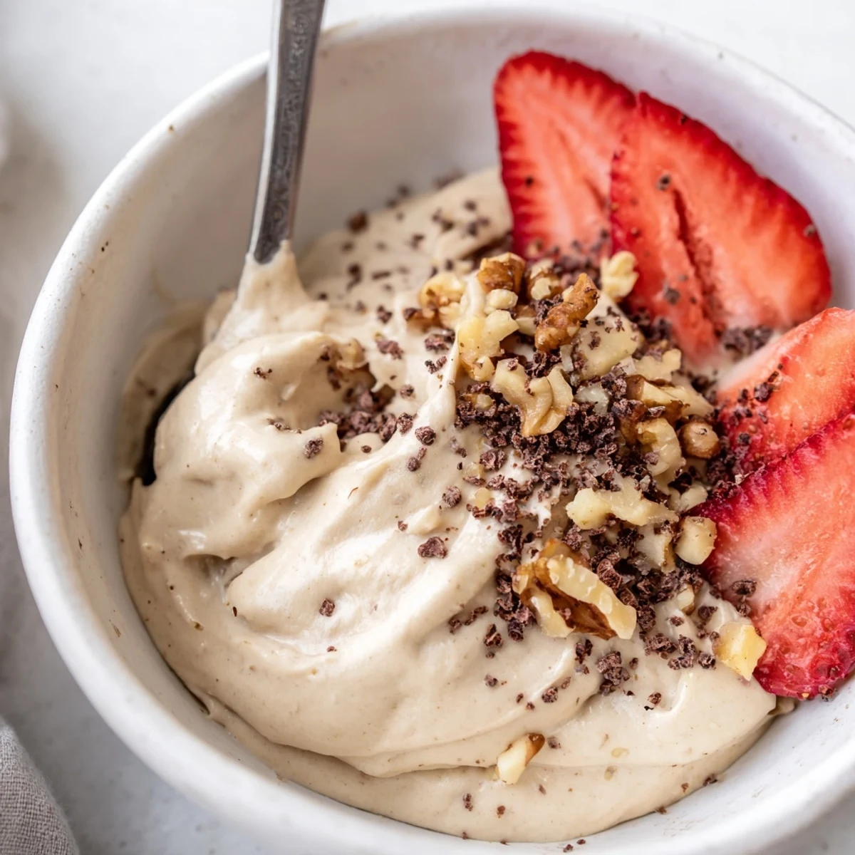 Creamy healthy nice cream scooped into bowls topped with fresh berries and nuts