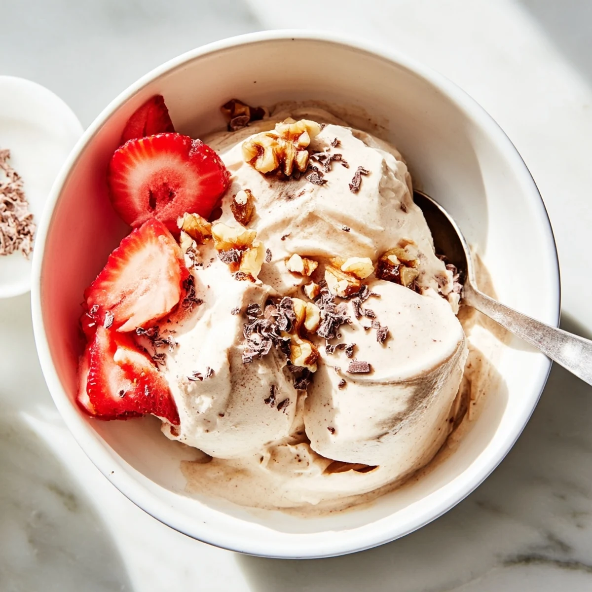 Vegan nice cream swirl in a glass garnished with banana slices and cacao nibs