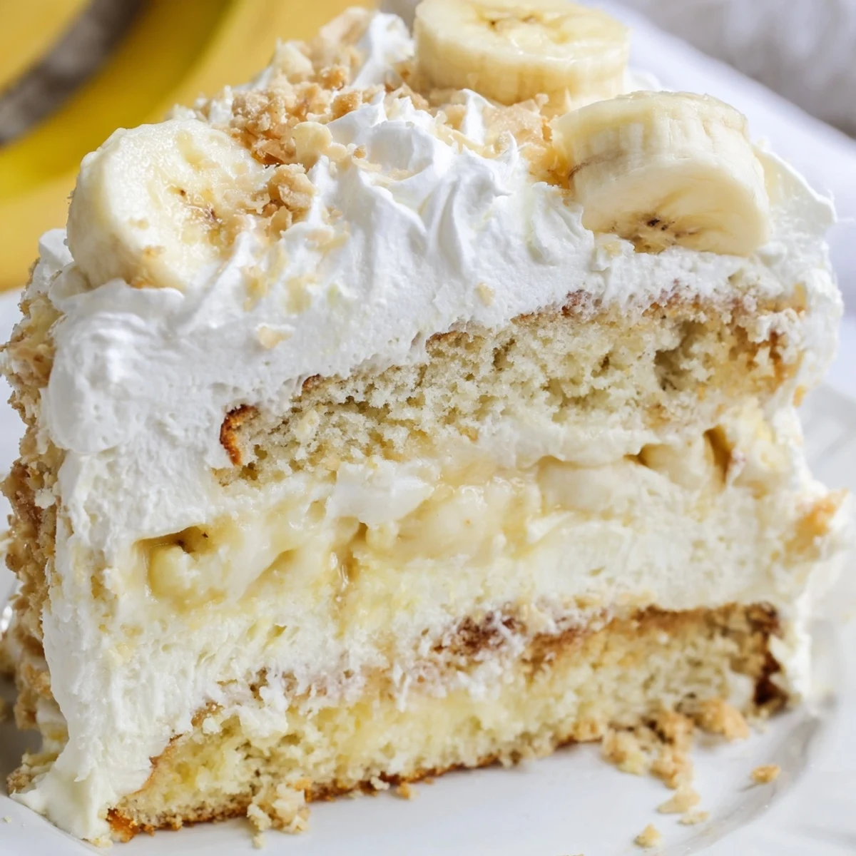 Moist banana pudding cake recipe with creamy vanilla filling sandwiched between tender golden cake layers