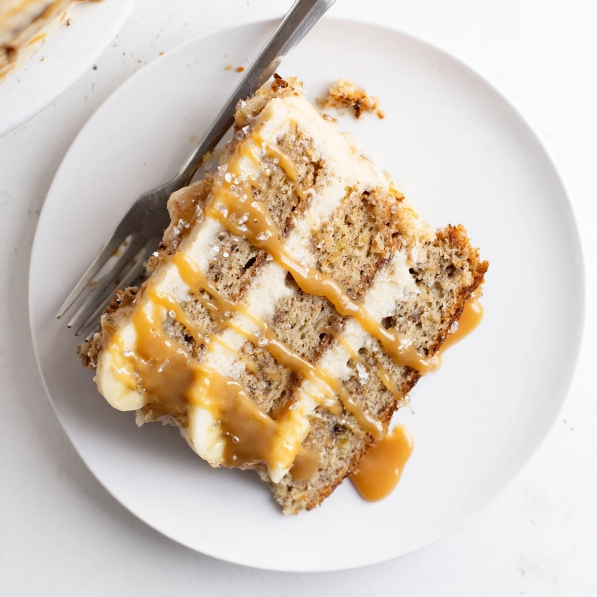 Decadent salted caramel brown butter banana cake slice showing caramel dripping down the side