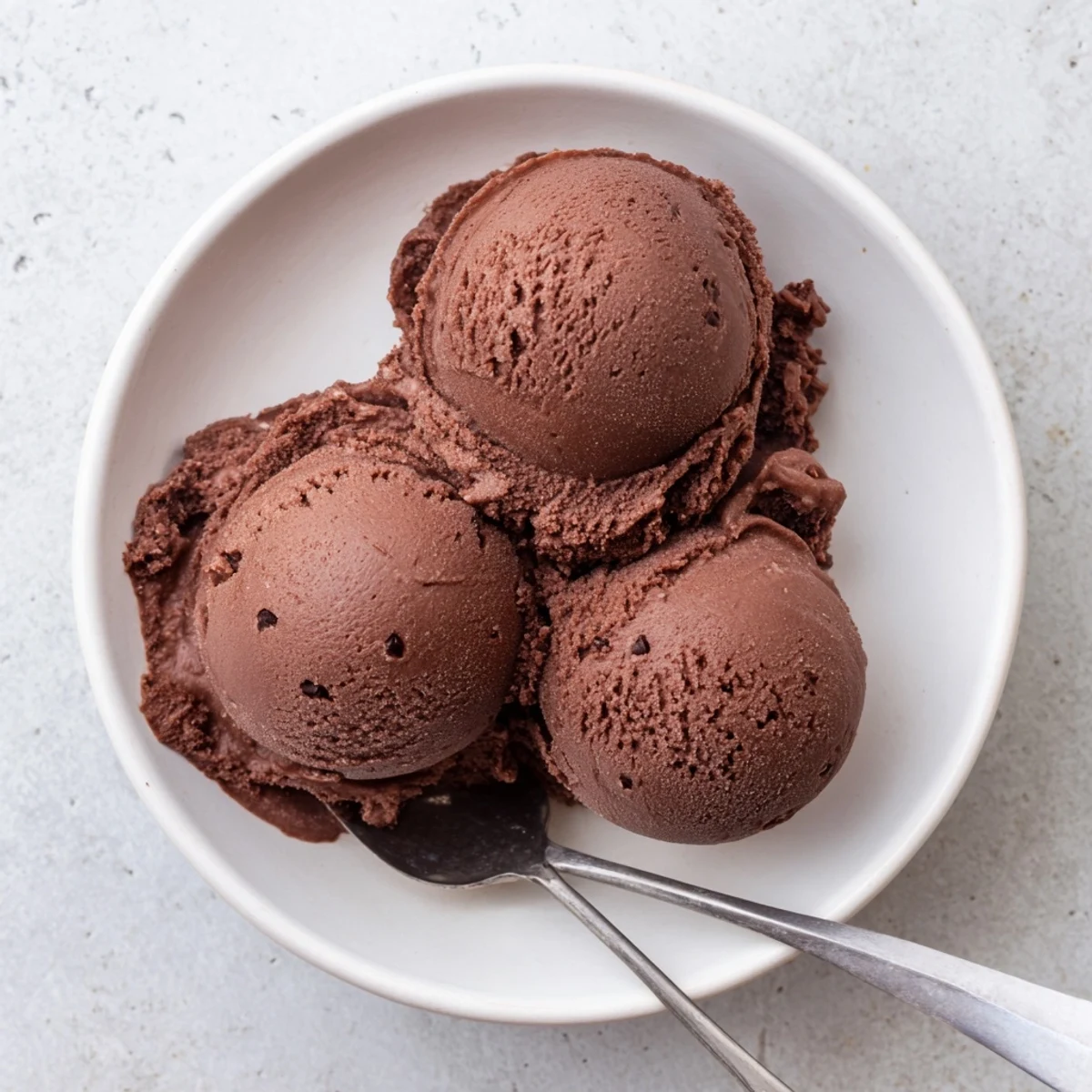 Creamy chocolate sourdough ice cream scooped into a chilled glass bowl with dark chocolate shavings on top