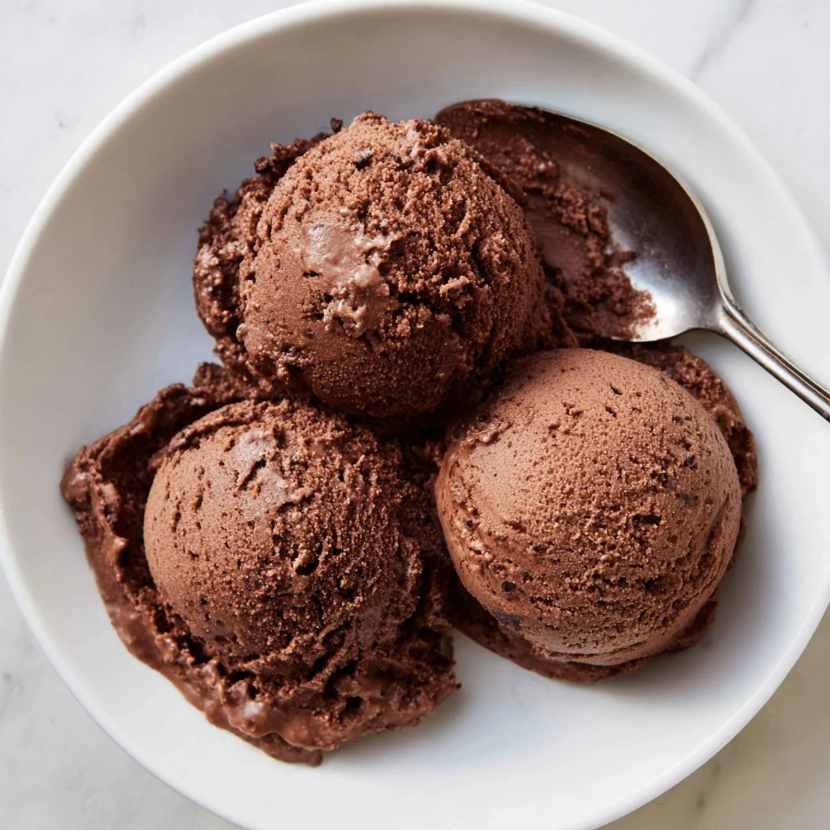 Rich dark chocolate sourdough ice cream swirling with tangy fermented starter in a vintage ceramic serving dish