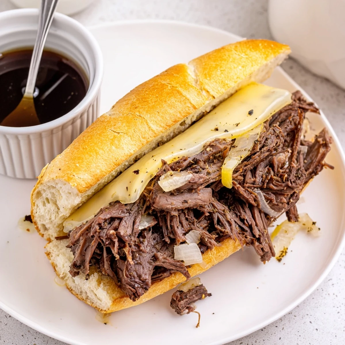Crockpot French Dip Sandwiches with shredded beef, melted provolone, au jus for dipping
