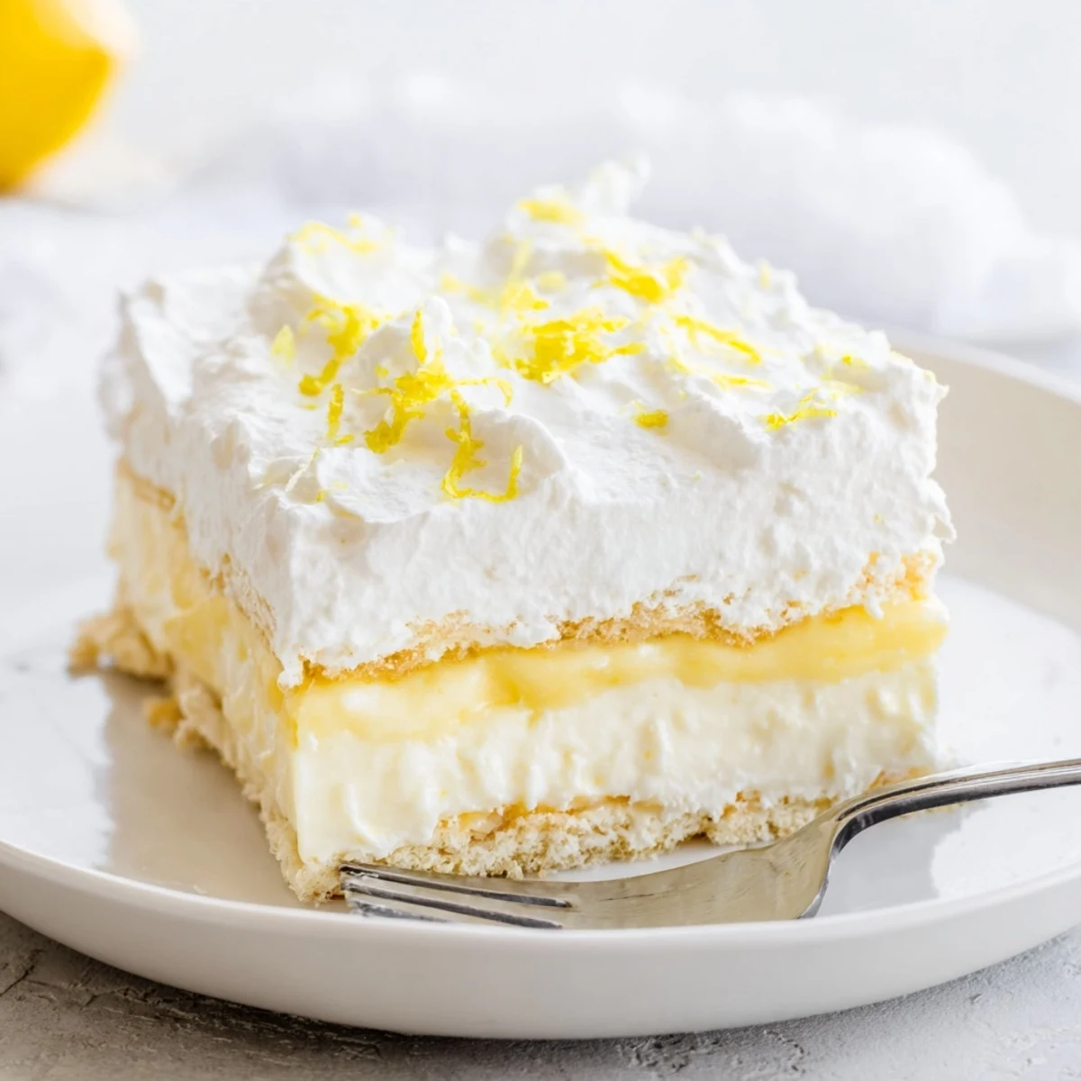 Sliced Lemon Lush Cake showing buttery crust tangy lemon layer and smooth cream cheese