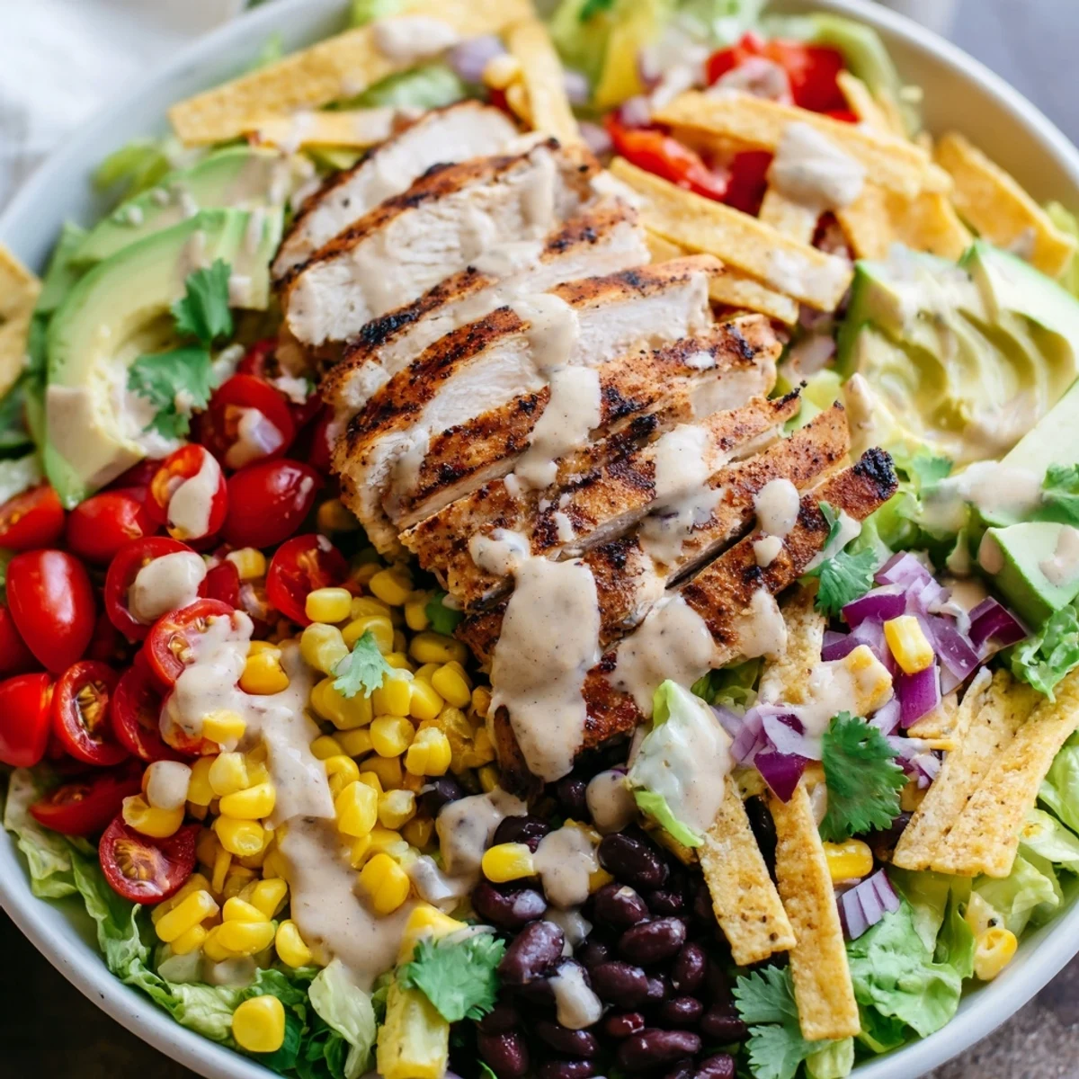 Hearty Southwestern chicken salad plated with seasoned chicken breast, colorful vegetables, beans, corn, and tangy lime dressing