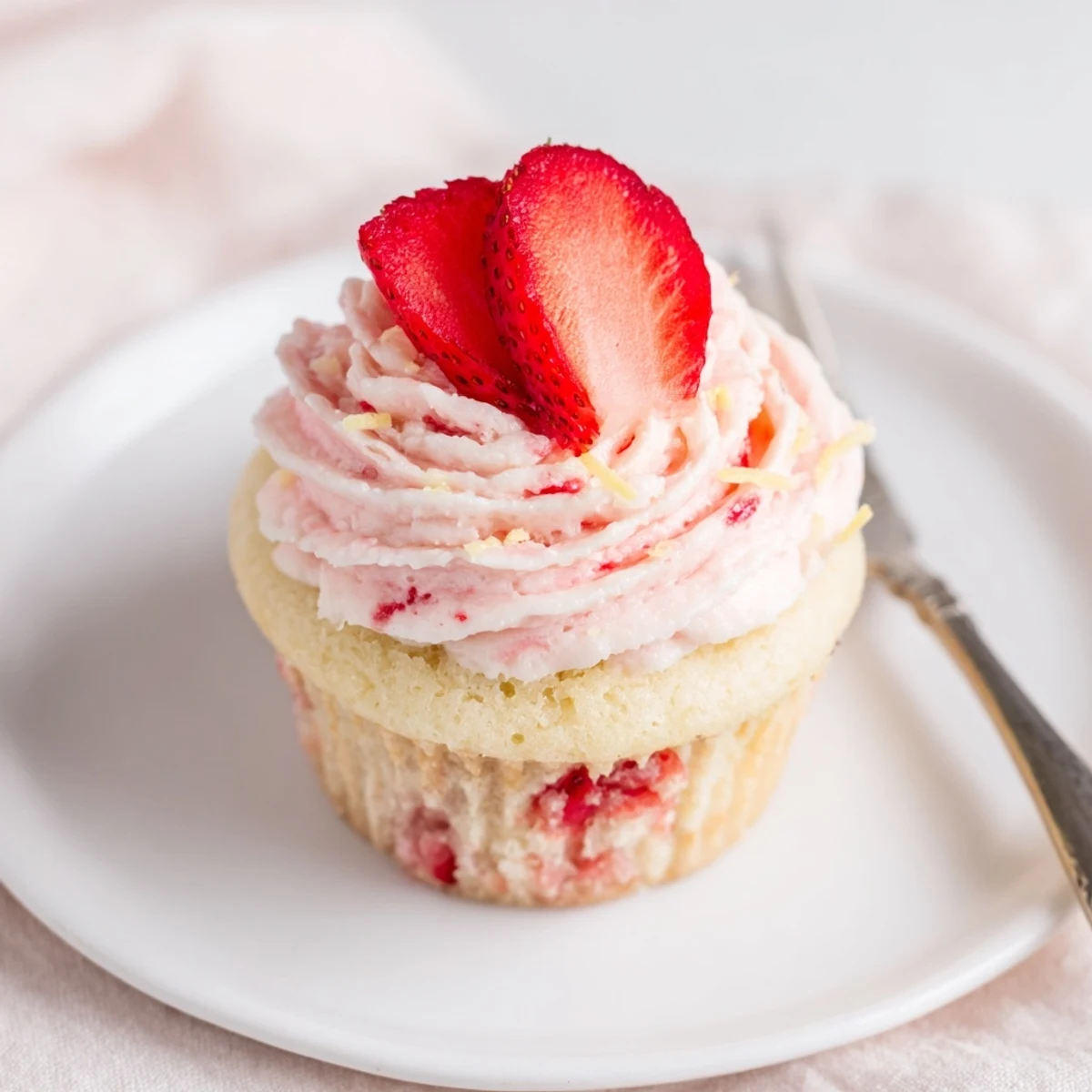 Plated Strawberry Lemonade Cupcakes beside sparkling lemonade, bright lemon aroma and berries