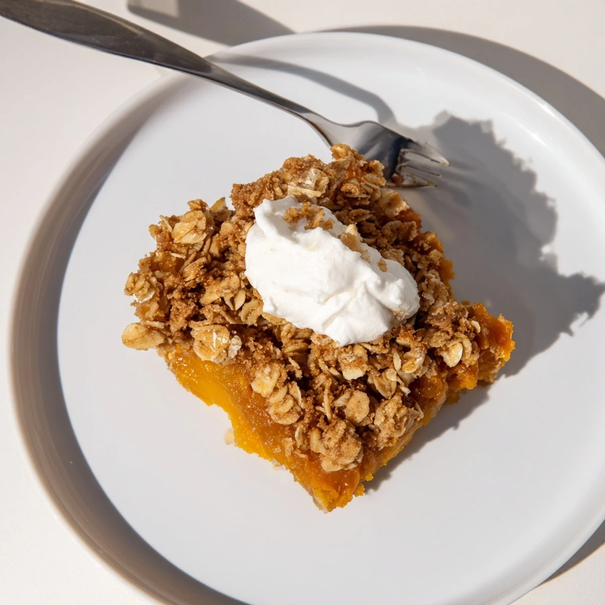 Creamy pumpkin pie crisp with golden oat crumble served warm in a baking dish